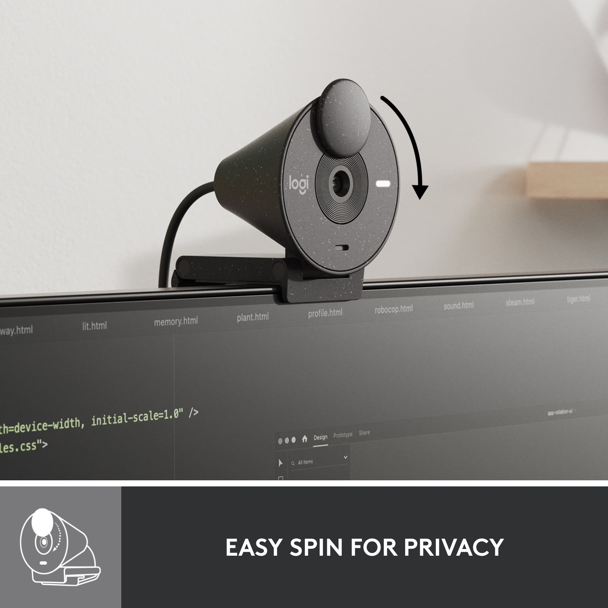 Une webcam noire avec un cache de confidentialité. Elle est au-dessus d'un moniteur. L'écran affiche du code.