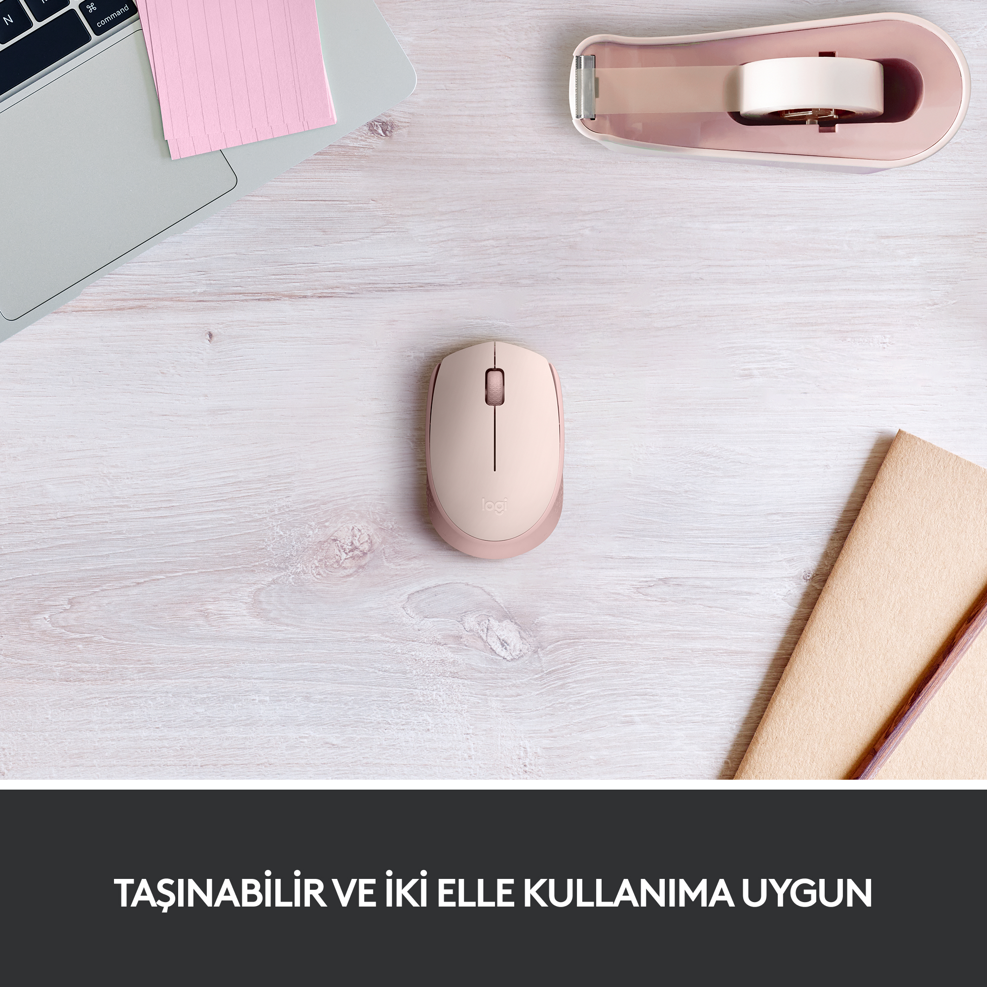 Ahşap masada pembe fare, pembe not defteri ve zımba ile.