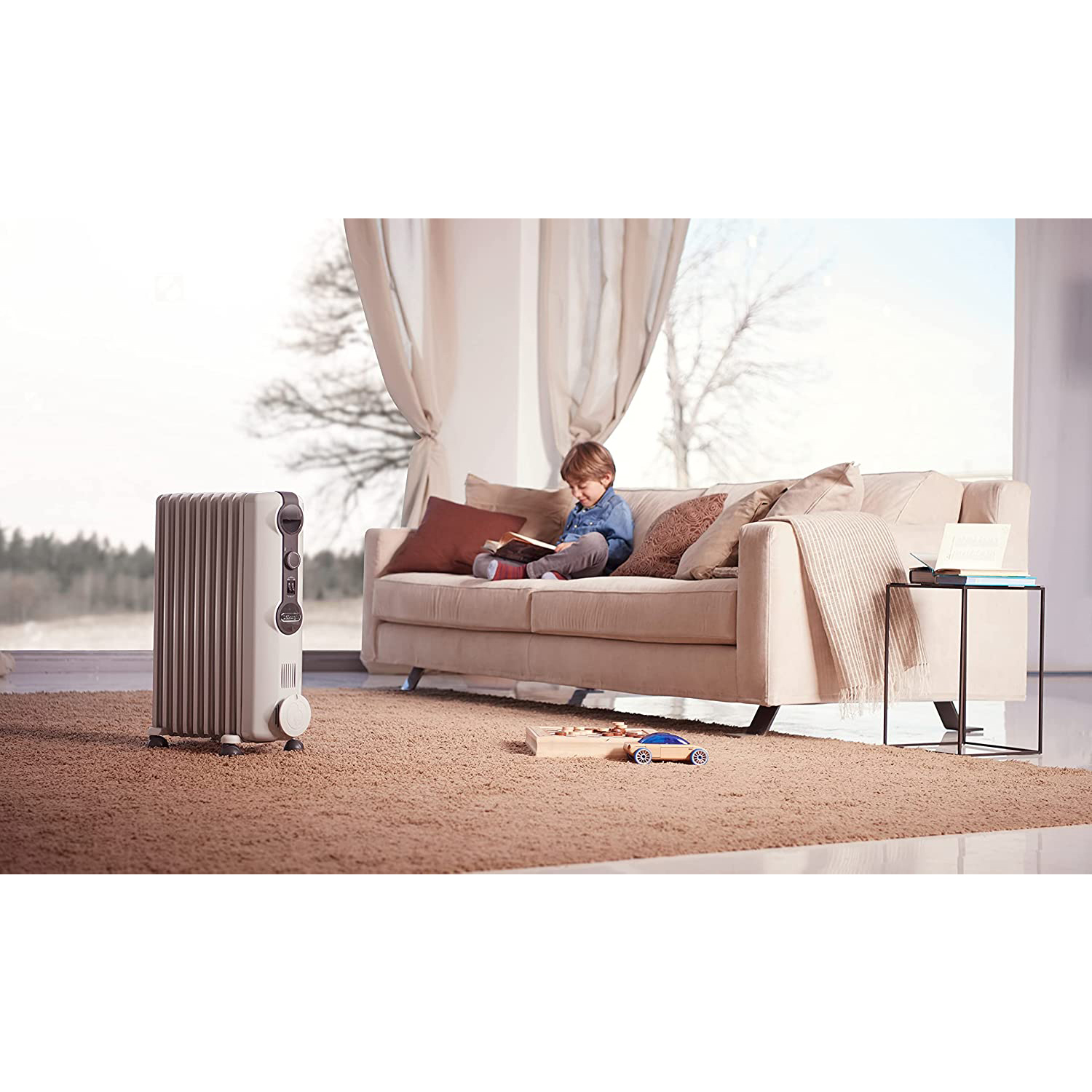 Soggiorno con bambino che legge sul divano. Termosifone a sinistra, finestra dietro.