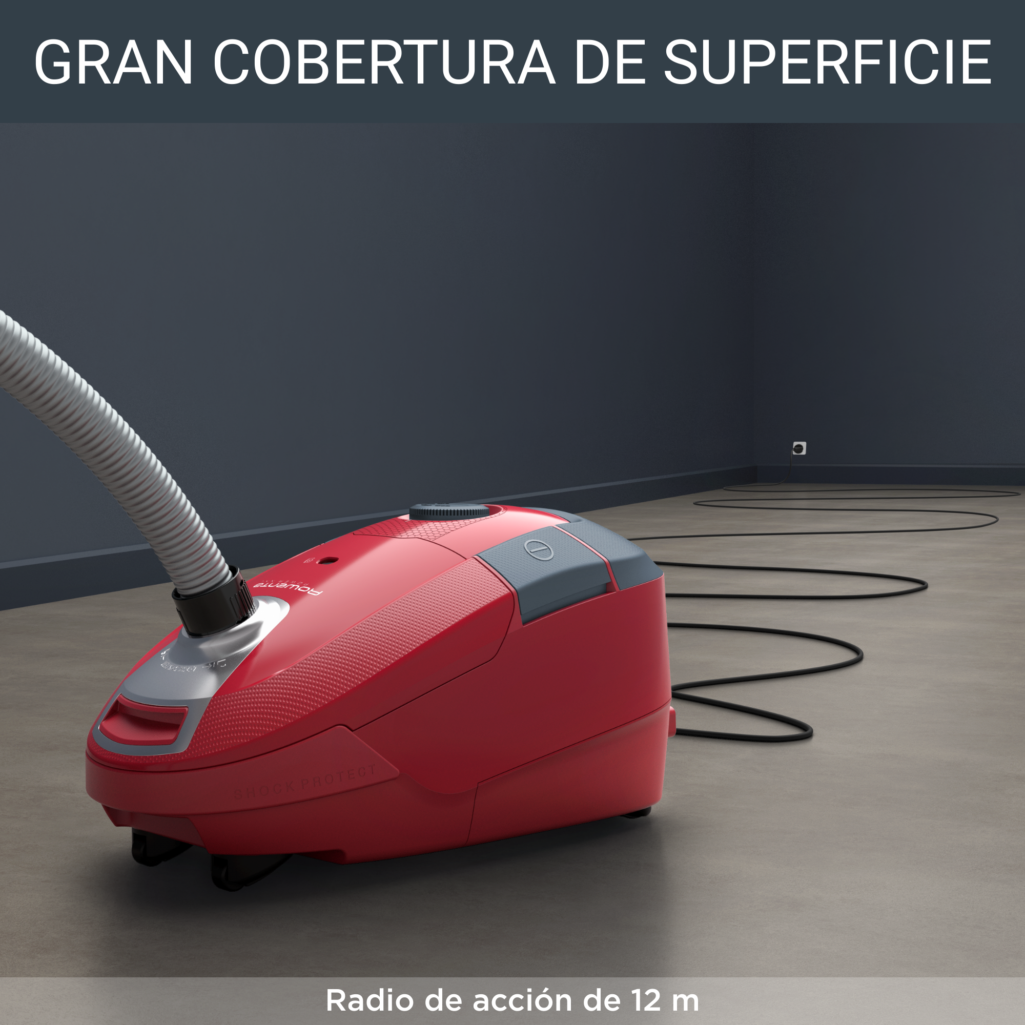 Aspiradora roja en suelo gris, fondo con pared gris oscuro. Manguera y cable negros.