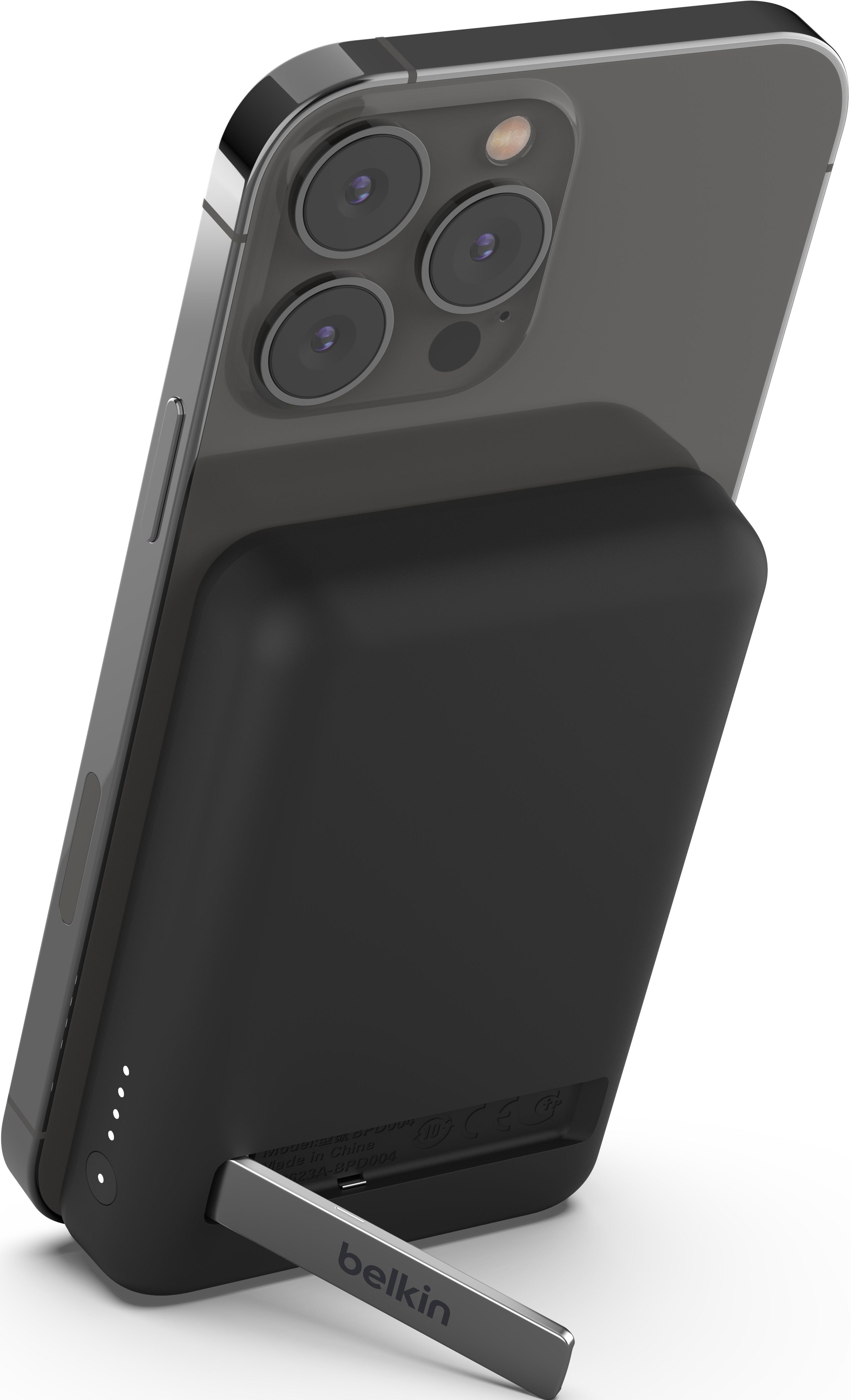 Un chargeur de téléphone Belkin noir est fixé à un téléphone. Le téléphone est incliné avec un pied.