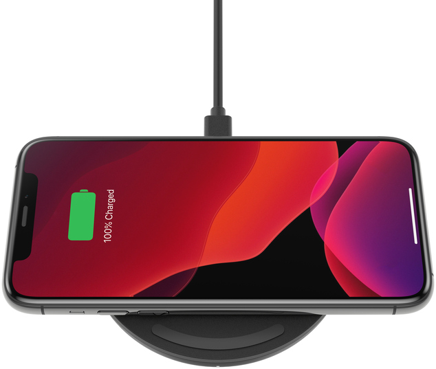 Smartphone se chargeant sans fil sur un socle de charge noir, affichant un indicateur de charge à 100%.