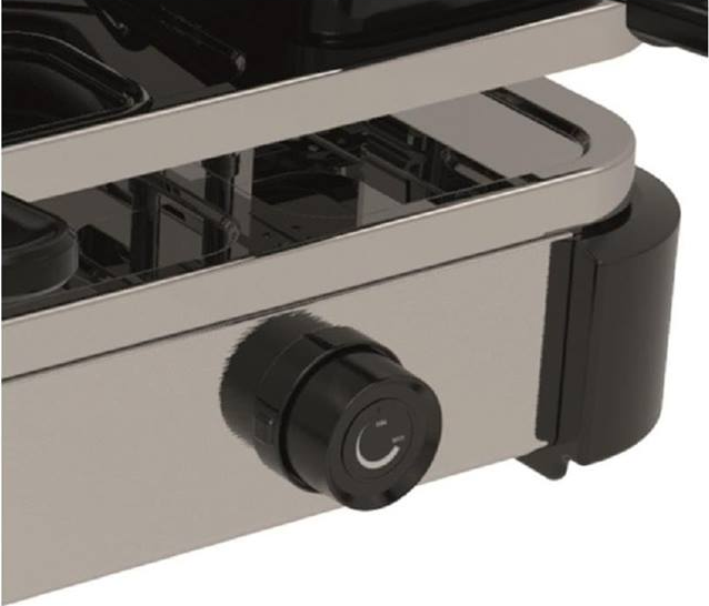 Primo piano della manopola di controllo di un elettrodomestico argento e nero con superfici metalliche.
