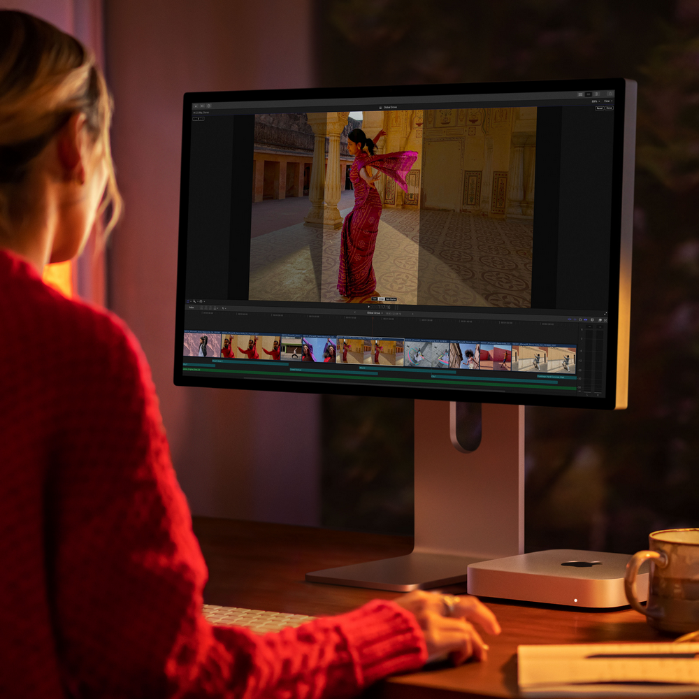 Una mujer que usa una computadora muestra un video de una mujer bailando con un sari colorido.