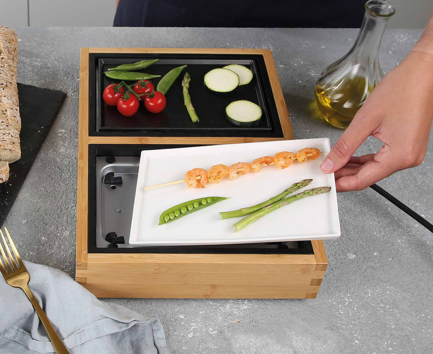 Une personne tenant une assiette avec des crevettes et des asperges, à côté de légumes sur un grill.