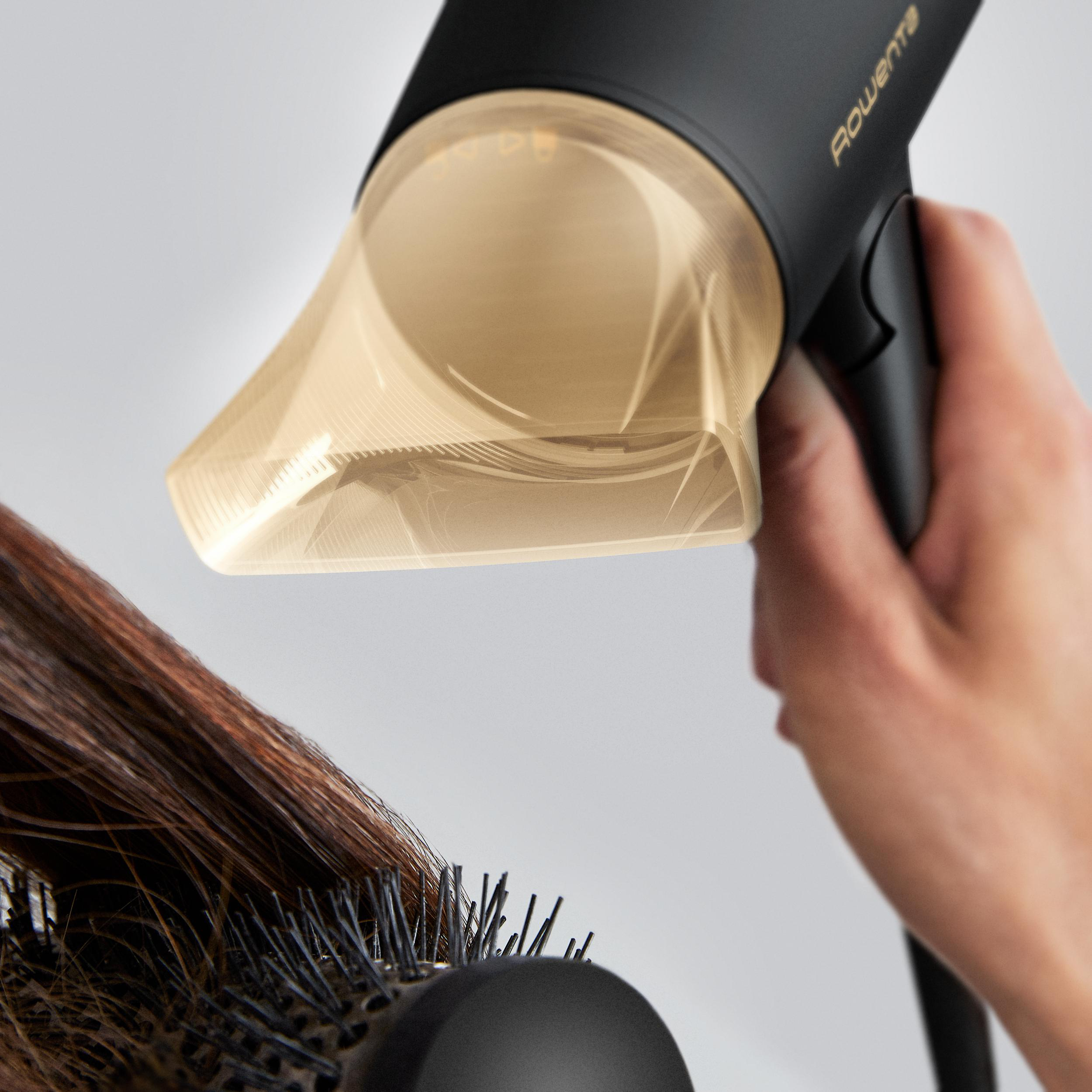 Person föhnt Haare mit einem Haartrockner.