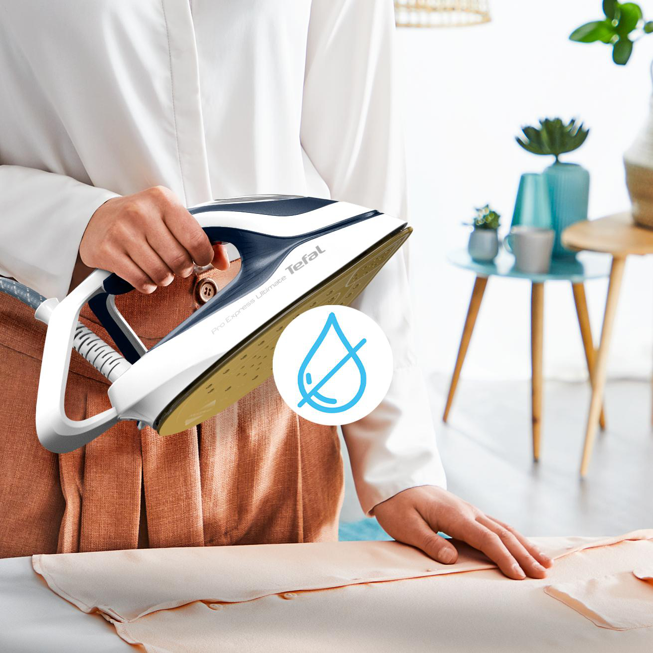 Person bügelt Kleidung mit einem weißen und blauen Bügeleisen. Ein Wassertropfensymbol ist sichtbar.