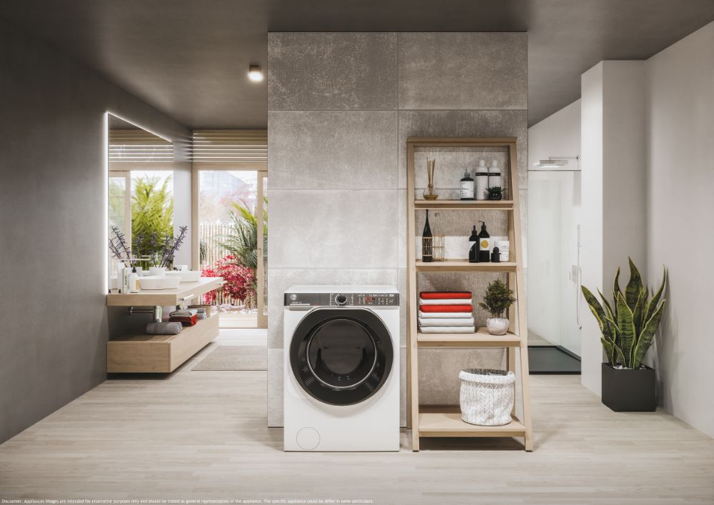Salle de bain moderne avec lave-linge, étagères en bois avec serviettes et plantes, et un grand miroir.