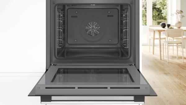 Backofen-Innenraum mit offener Tür. Der Innenraum ist schwarz und metallisch.