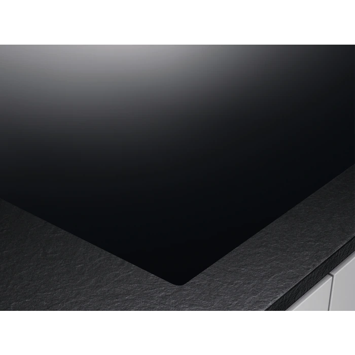Primer plano de una placa de inducción negra, mostrando una superficie oscura y elegante.