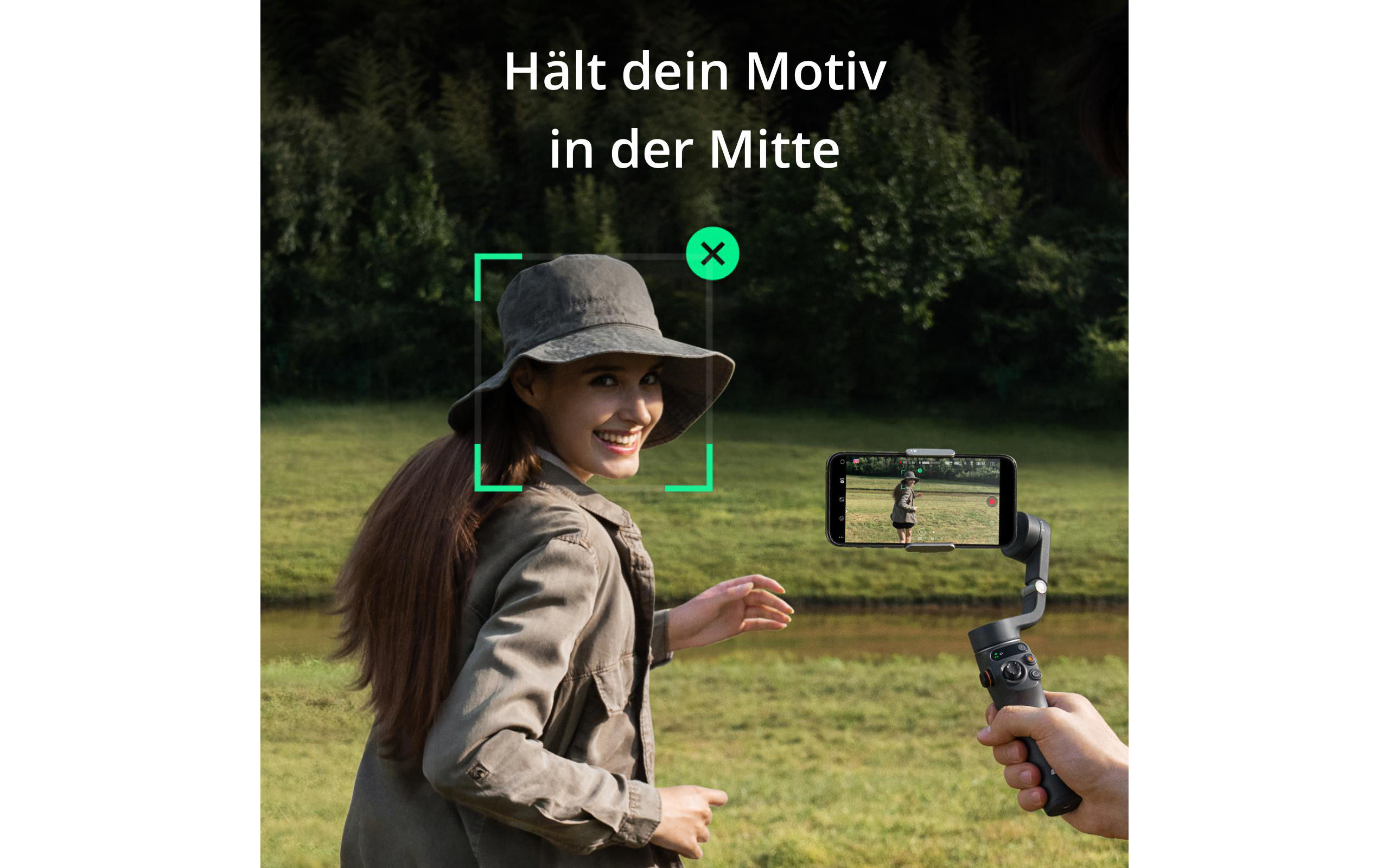 Eine Frau filmt mit einem Handy auf einem Gimbal in einem grünen Feld.