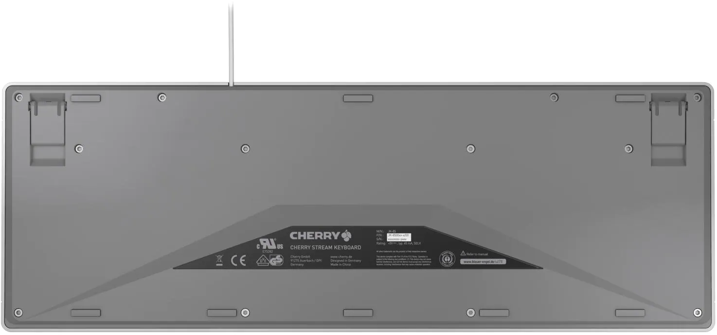 Le dessous d'un clavier Cherry Stream gris est montré. Il possède des pieds de support, des vis et une étiquette avec le logo et les spécifications Cherry.