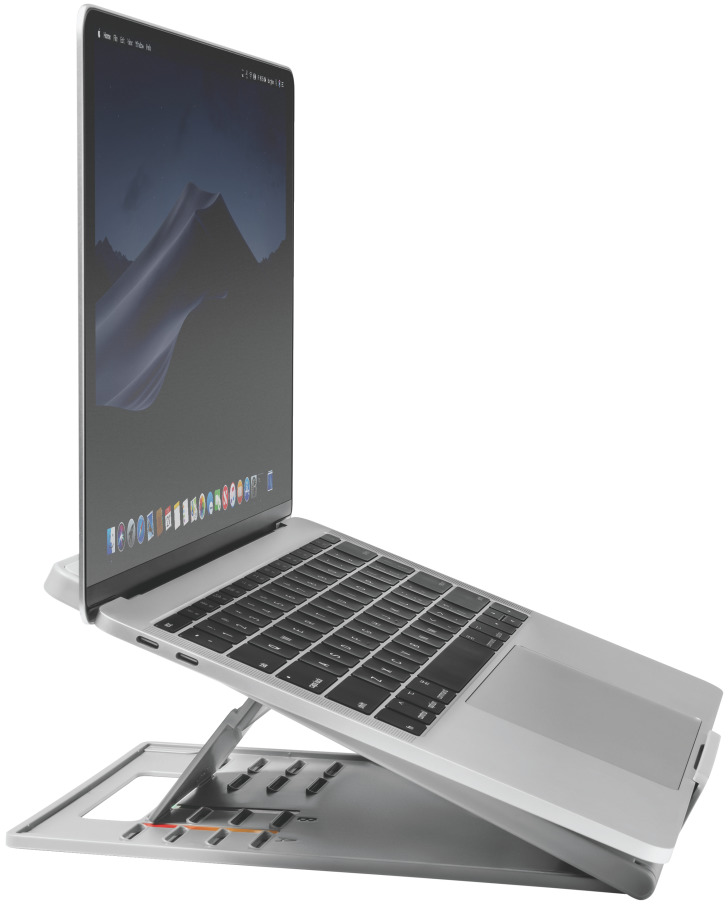 Egy ezüst laptop egy szürke állványon. A képernyő egy hegyláncot jelenít meg.