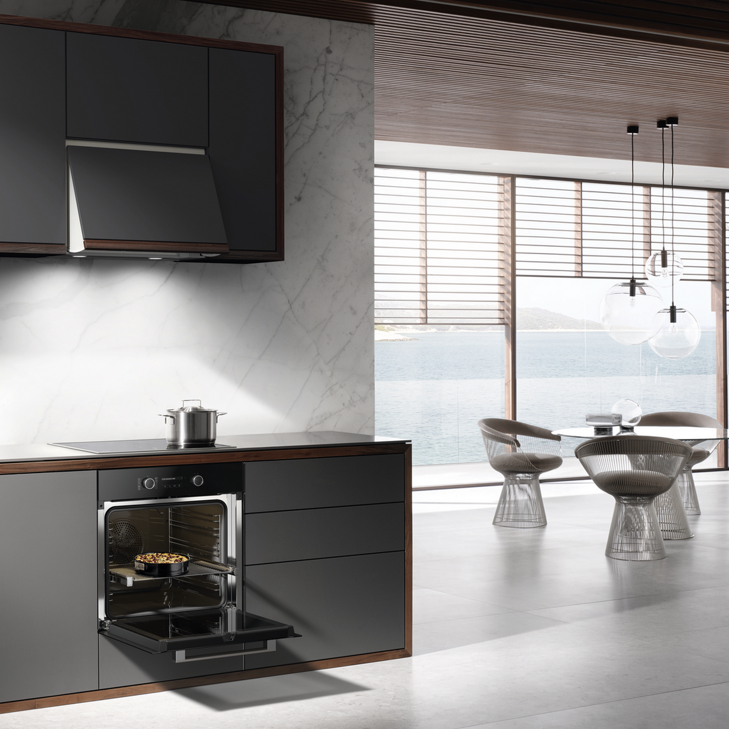 Kitchen with oven open, food inside. Background shows water, chairs, and a table.