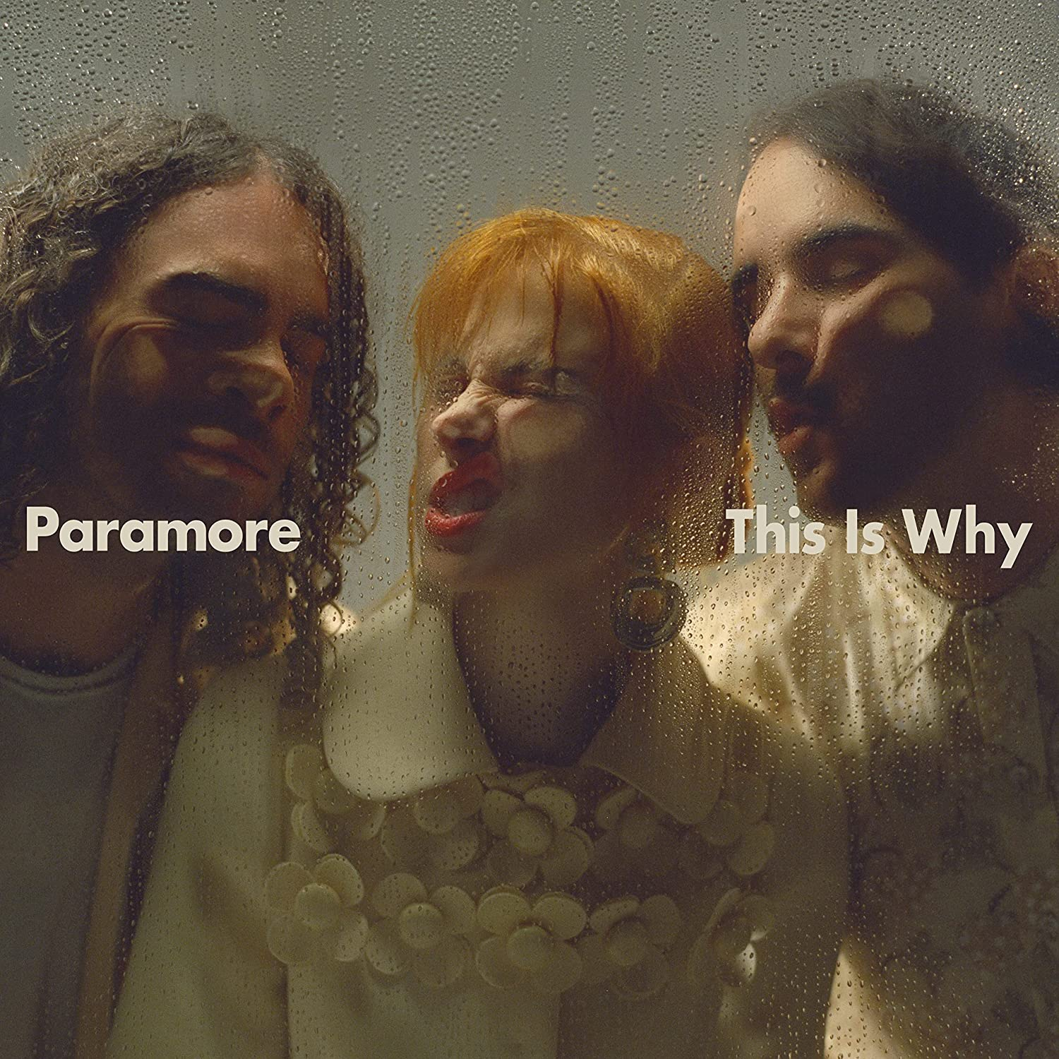 Lemezborító három zenekari taggal egy nedves üveg mögött. Paramore és This Is Why szövegek a borítón.