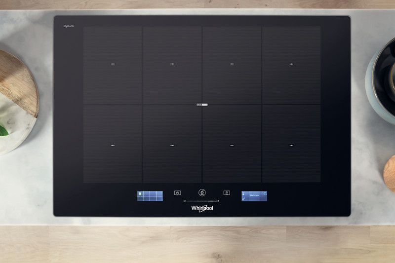 Fekete indukciós főzőlap márvány felületen, digitális kijelzőkkel és Whirlpool logóval.