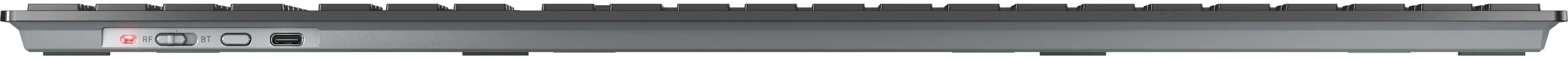 Die Unterseite einer grauen Tastatur mit Anschlüssen an der Seite. Der Hintergrund ist weiß.