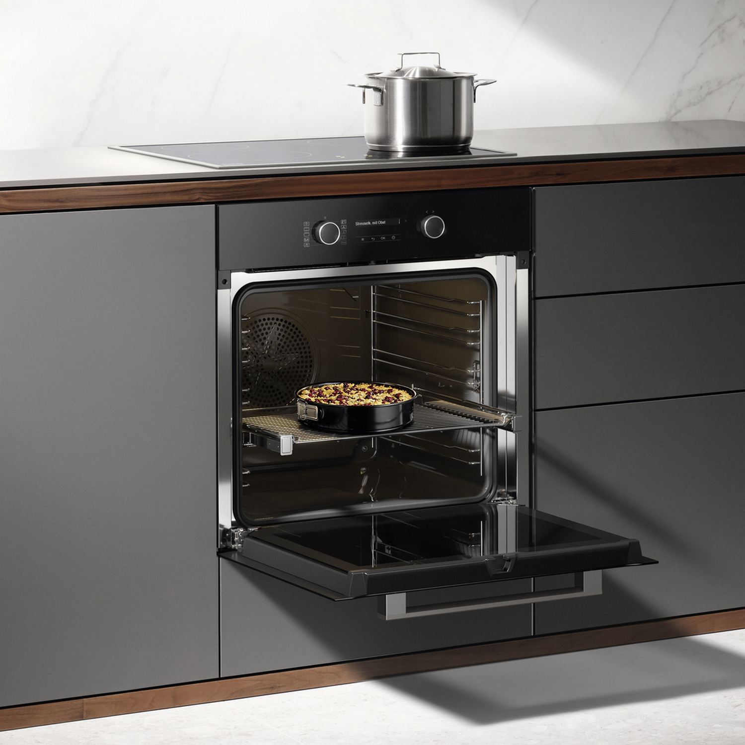 An open oven with a pie inside. A pot sits on the stovetop.