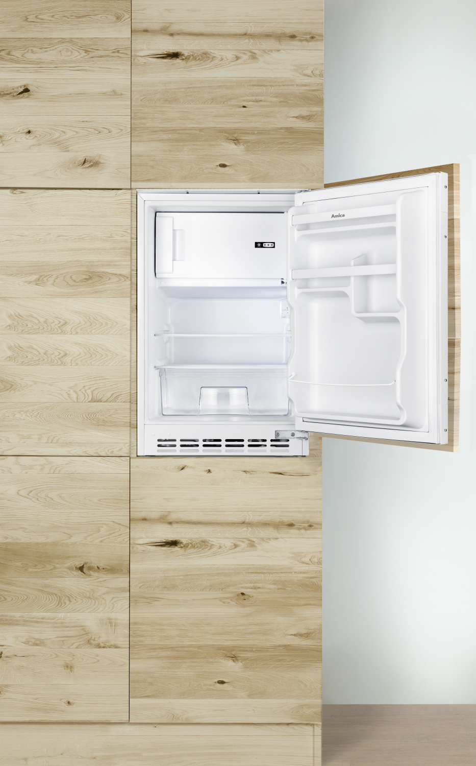 Ein offener, weißer Kühlschrank in einer Holzwand. Das Innere des Kühlschranks mit Regalen ist sichtbar.