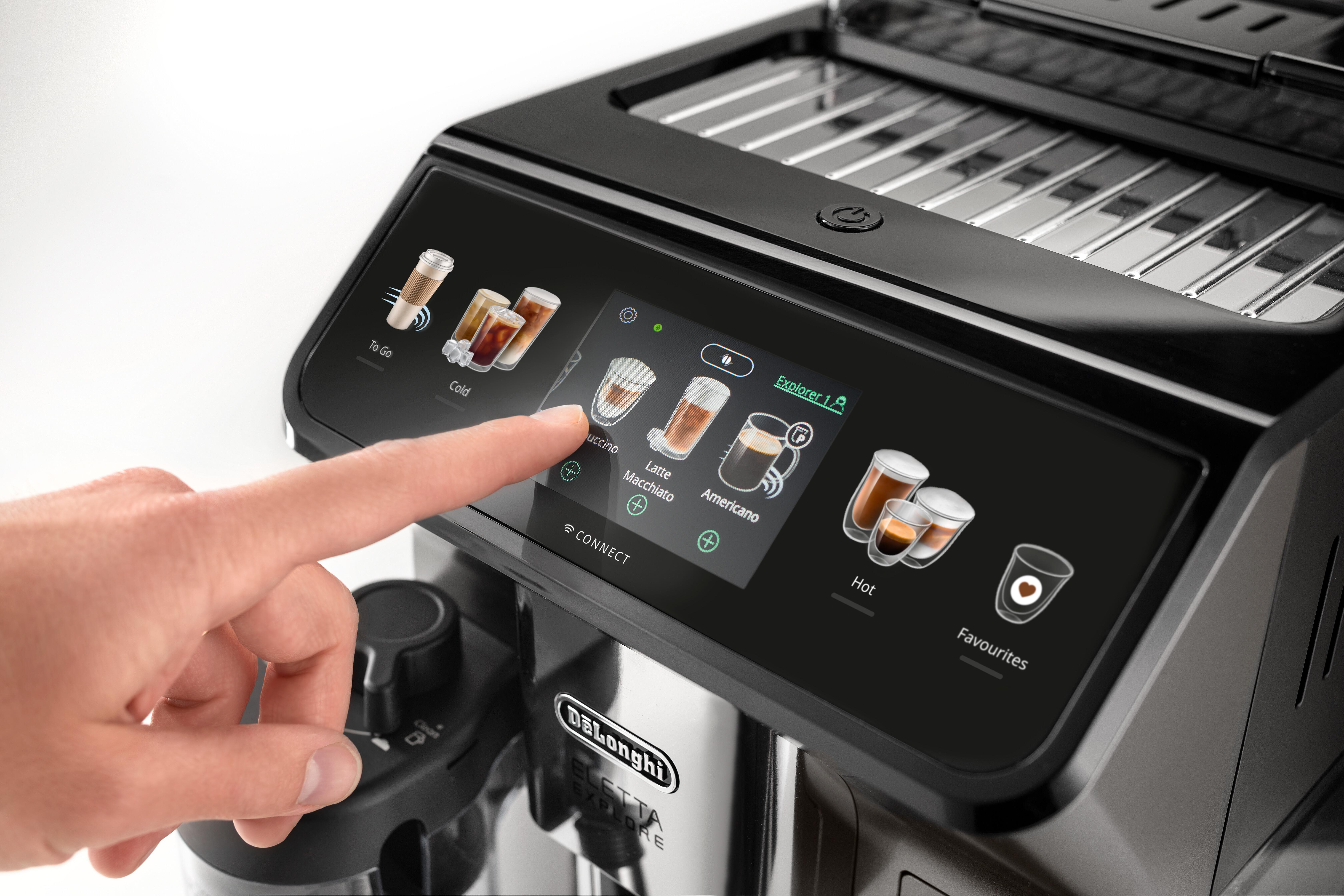 Nahaufnahme einer Kaffeemaschine mit Touchscreen. Ein Finger berührt den Touchscreen und wählt eine Kaffeeoption aus.