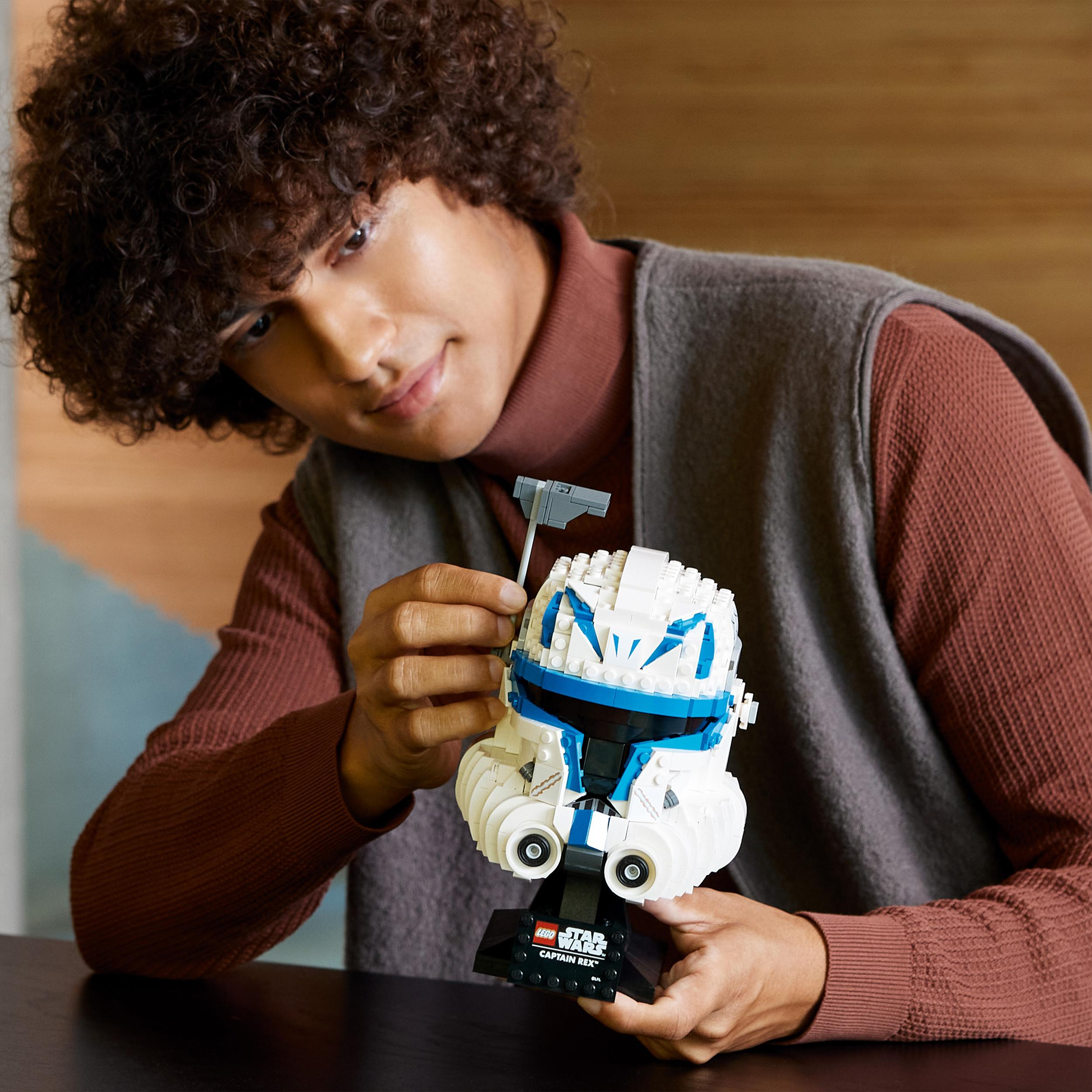 Eine Person hält einen Lego Star Wars Helm, das Modell im Vordergrund.