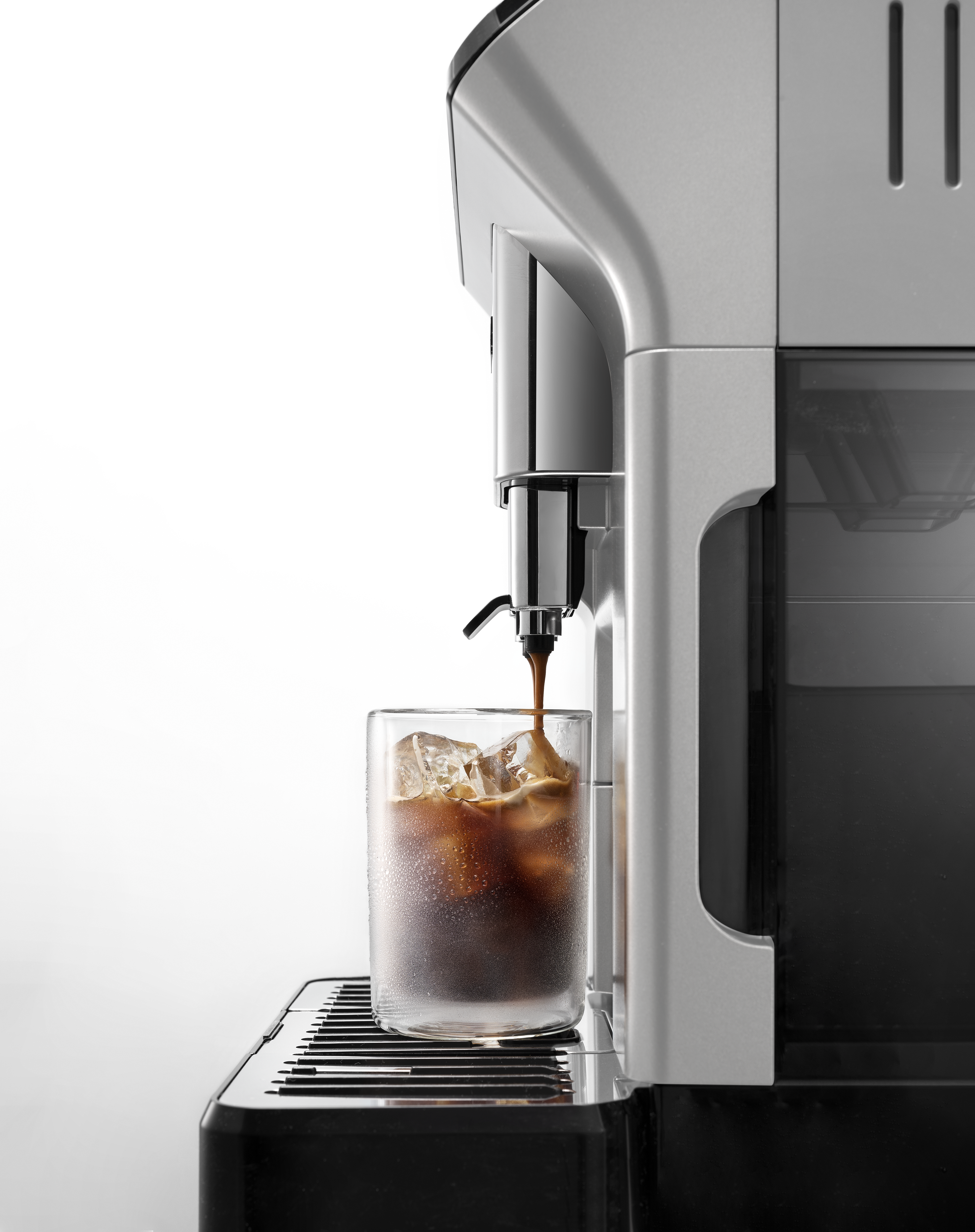 Kaffeemaschine, die Kaffee in ein Glas mit Eiswürfeln ausgibt. Weißer Hintergrund.