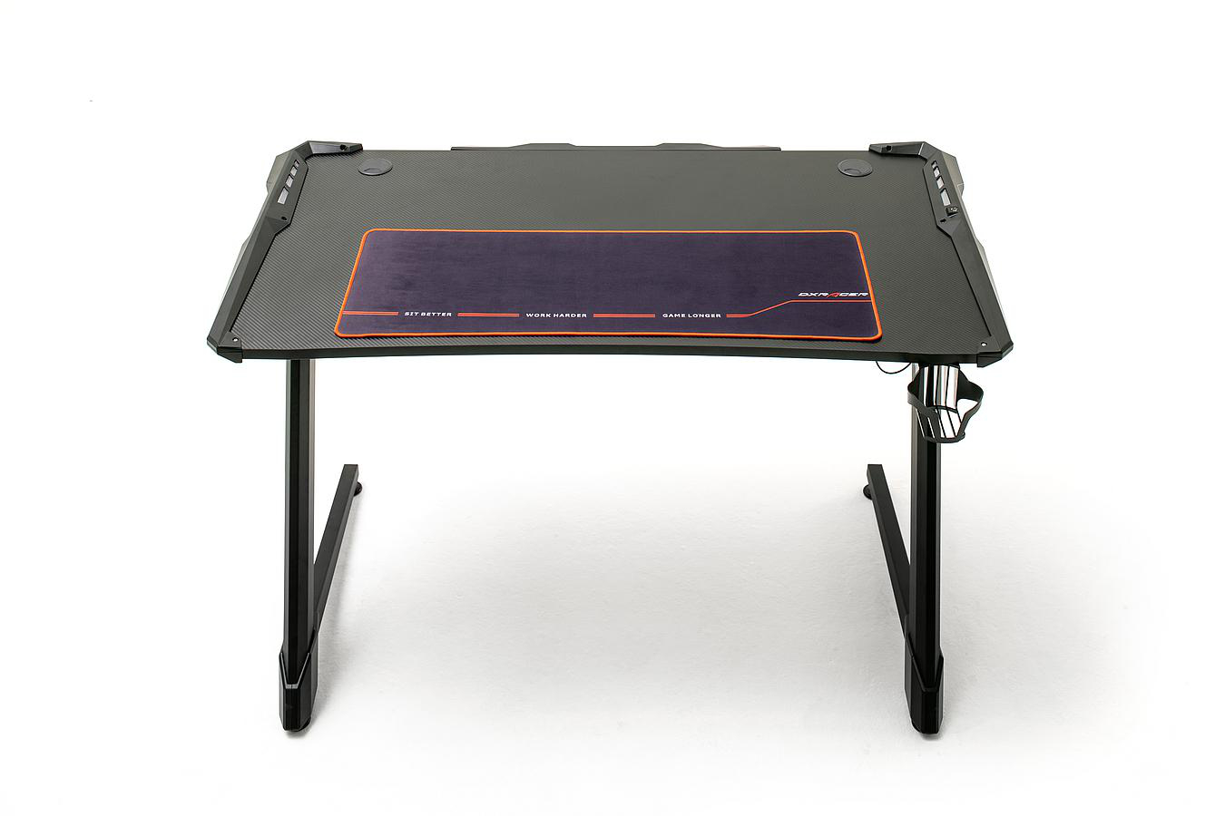 Gaming-Schreibtisch mit carbonfaserähnlicher Oberfläche, orangefarbenem Mauspad und schwarzen Beinen.
