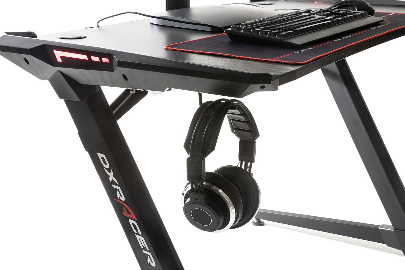 Gaming-Schreibtischecke mit hängendem Headset und schwarzer Tastatur, DXRacer-Logo sichtbar.