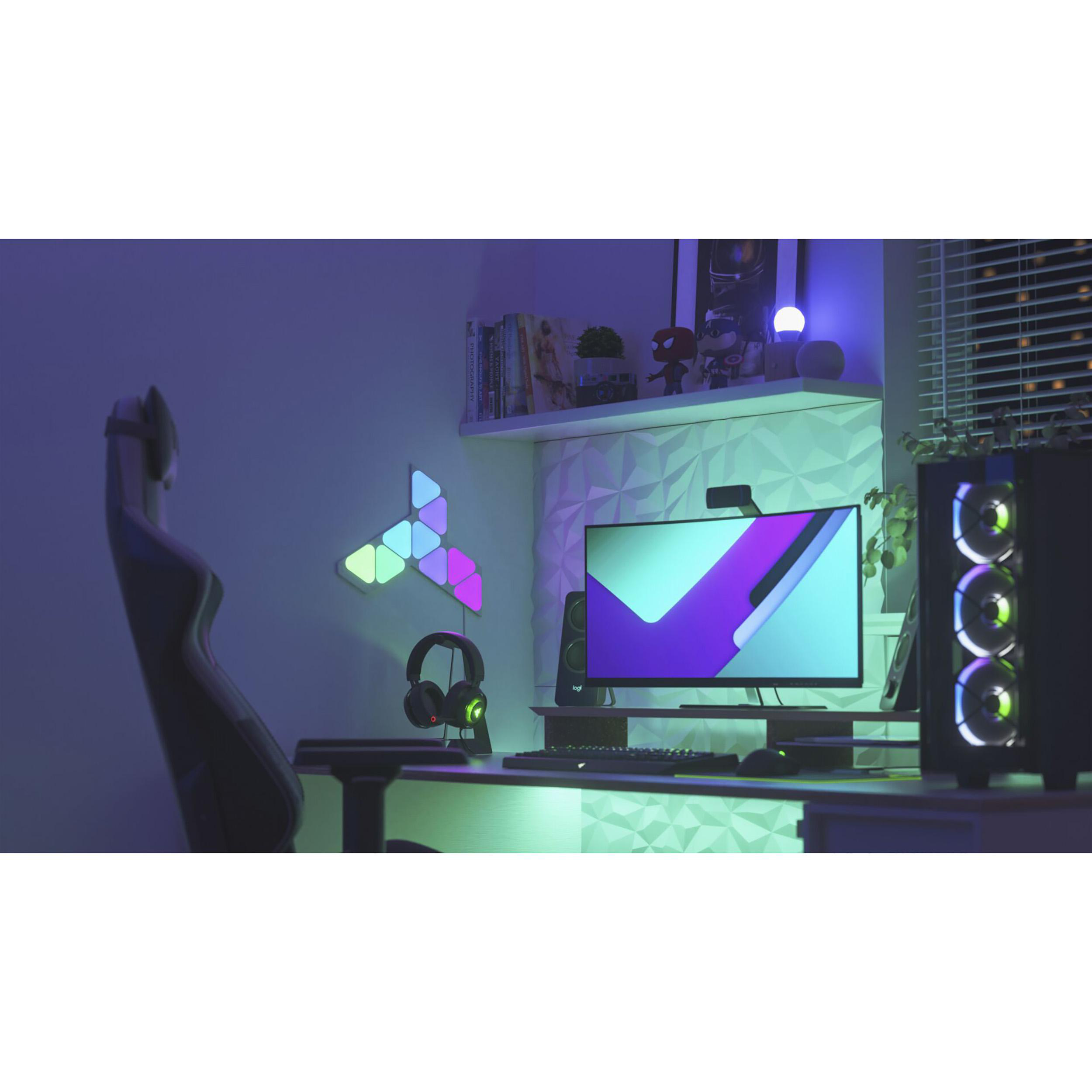 Ein Gaming-Setup mit Monitor, Lichtern und Zubehör auf einem Schreibtisch.