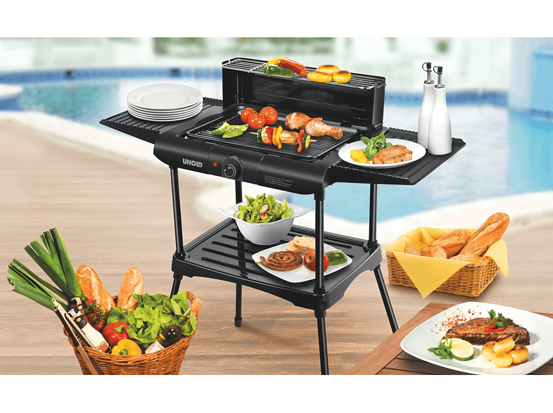 Elektromos grill ételekkel, tányérokkal és evőeszközökkel a teraszon. A háttérben medence.