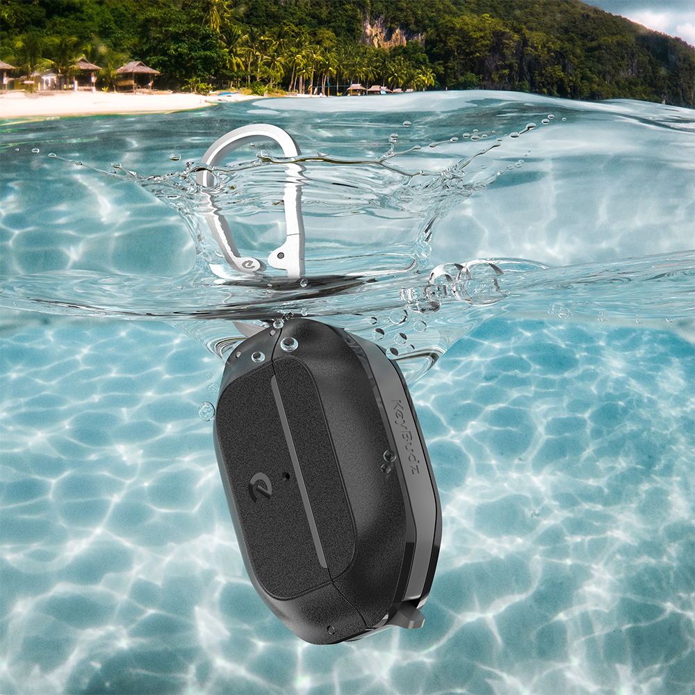 Schwarzer Lautsprecher schwimmt in klarem Wasser. Ein silberner Karabiner ist befestigt.