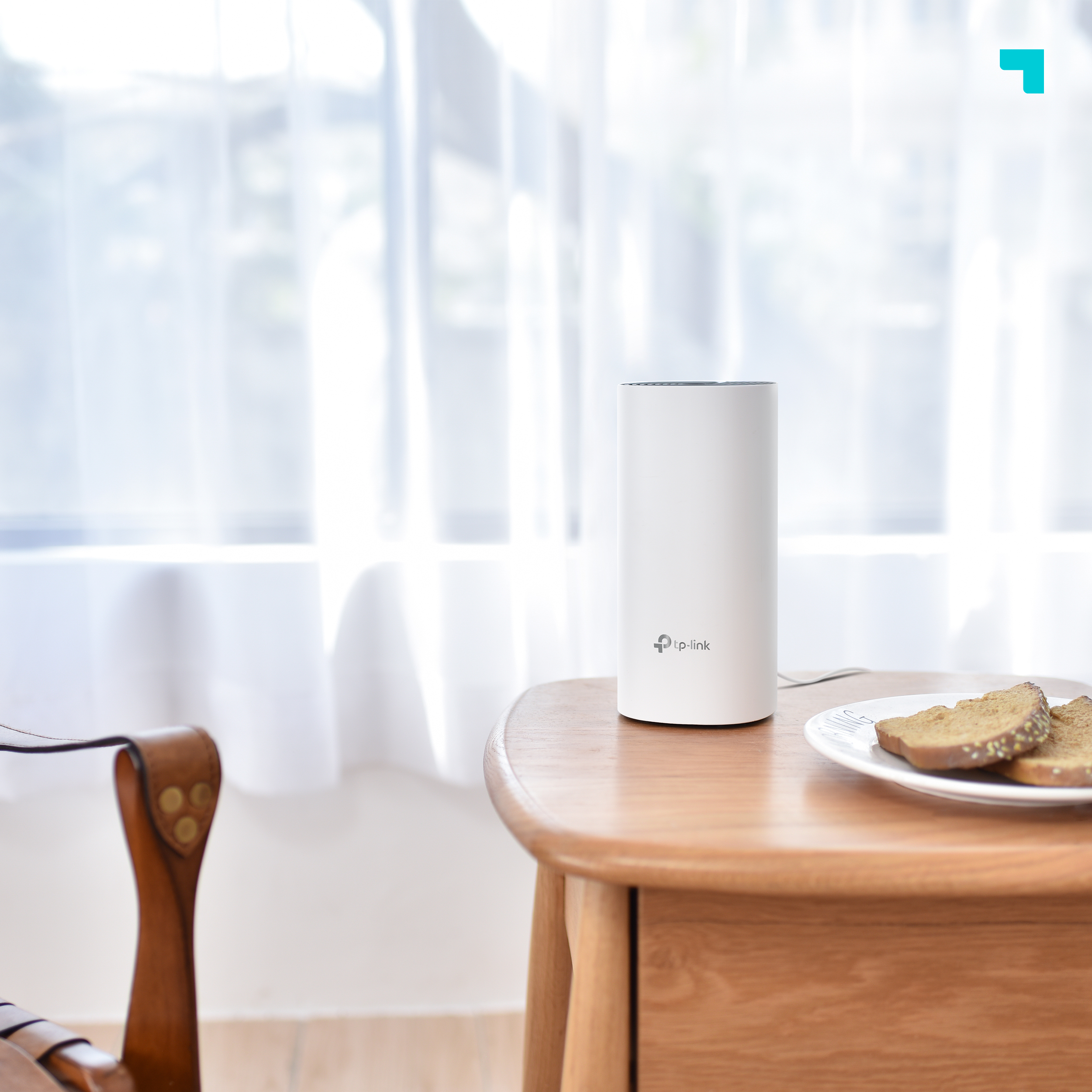 Un router TP-Link blanco sobre una mesa de madera, junto a dos rebanadas de pan.