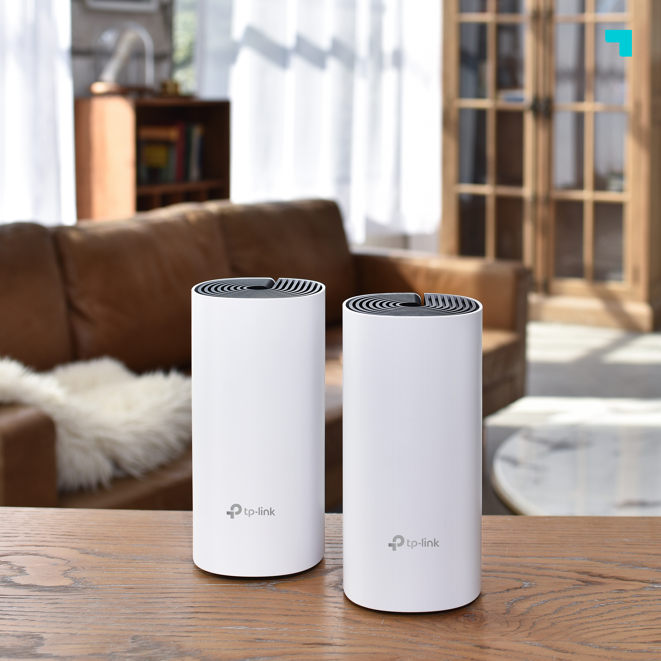 Dos dispositivos TP-Link mesh Wi-Fi blancos sobre mesa de madera. Fondo: salón.
