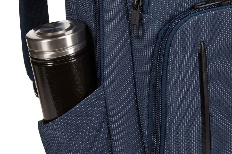 Bolsillo de mochila azul con botella de agua.