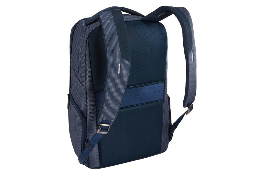 Mochila azul marino con múltiples compartimentos y correas. Fondo claro.