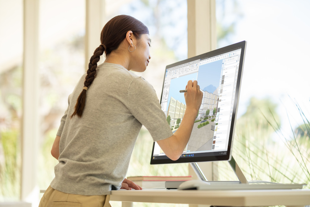Woman using a stylus on a large computer screen. She is working on a design program.