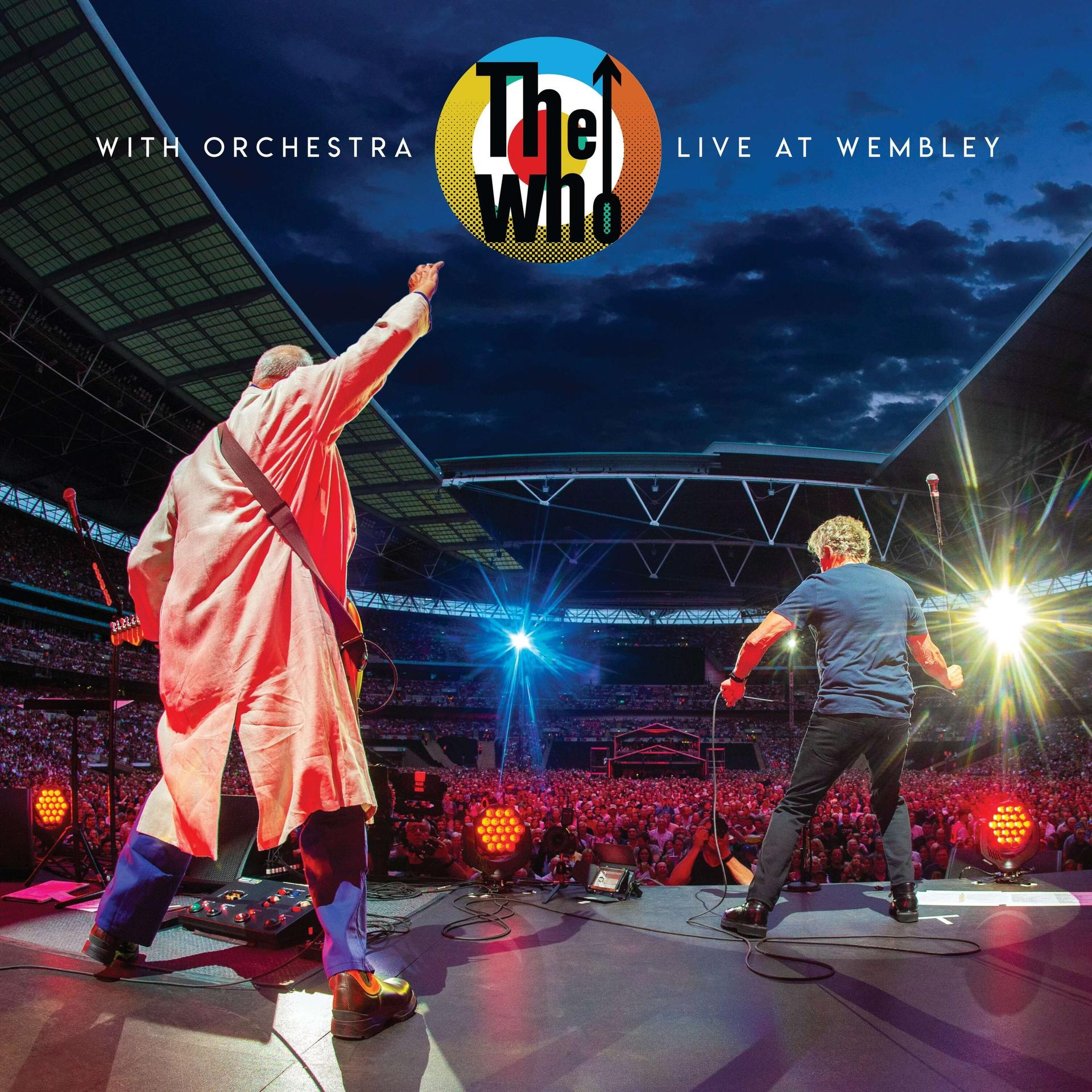 Live-Konzertbühne. Die Band The Who spielt. Helle Lichter, Publikum. Der Himmel ist bewölkt.