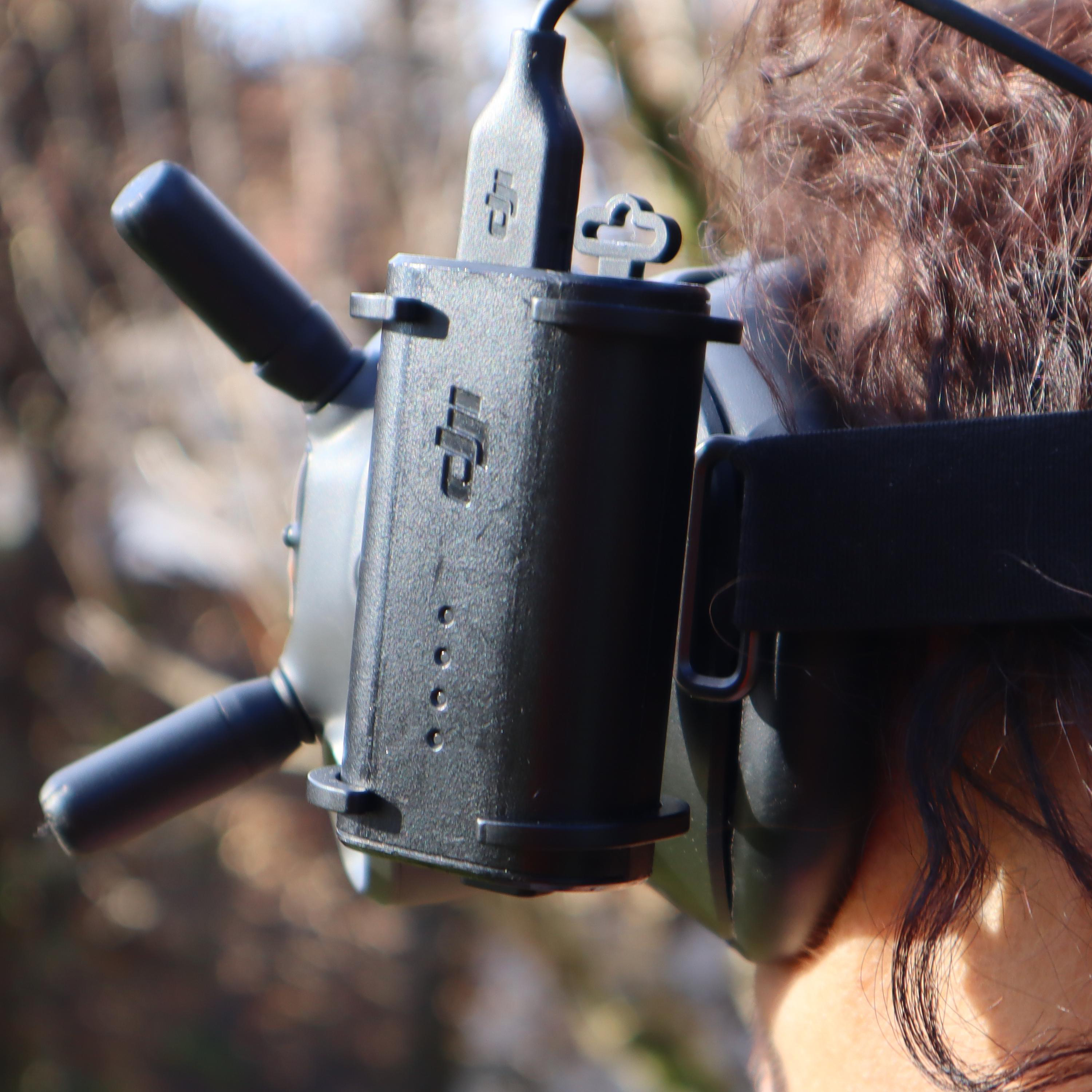 Eine Person, die ein Drohnen-Headset mit einem schwarzen Gerät trägt.