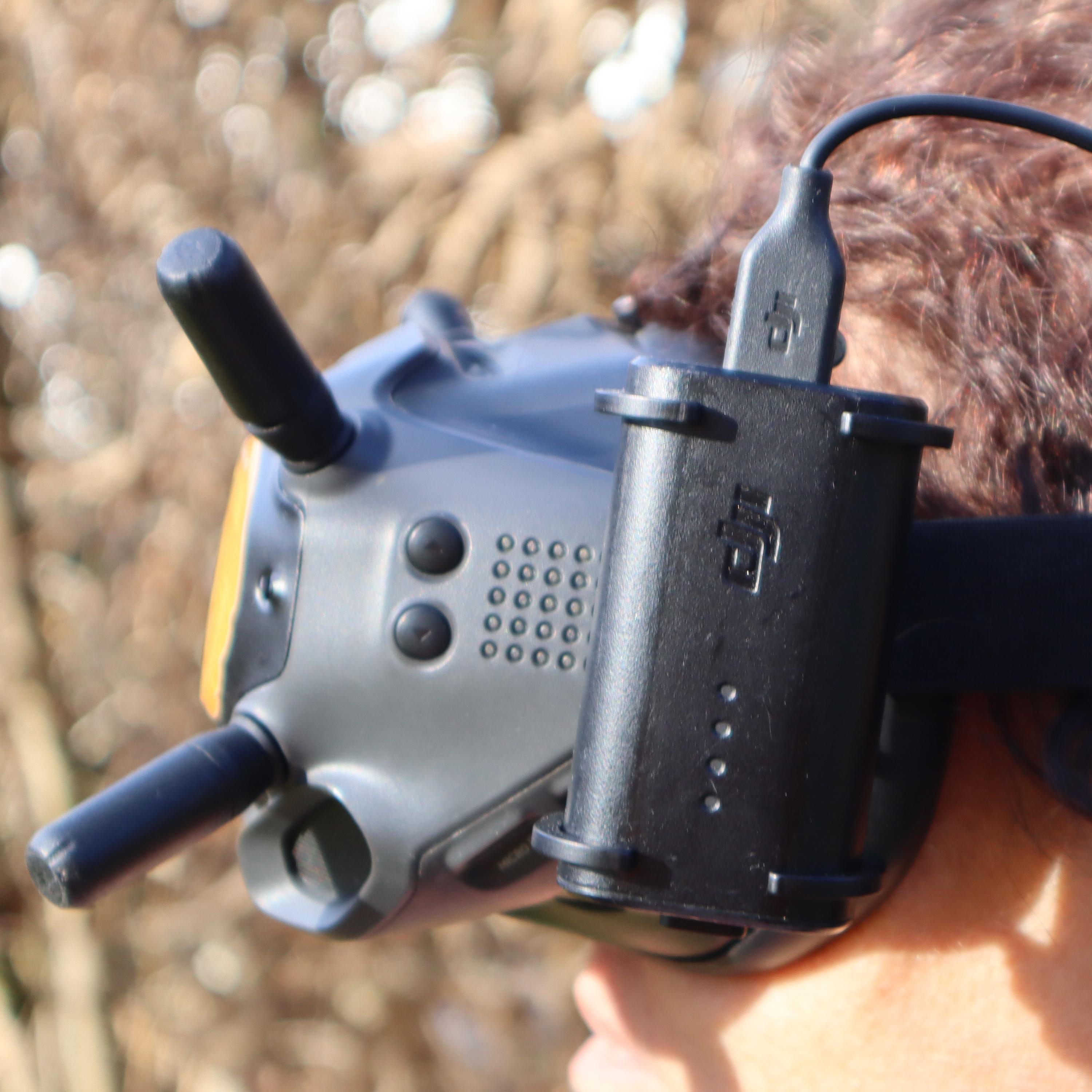 Eine Person, die ein VR-Headset trägt, angeschlossen an ein schwarzes Akkupack.