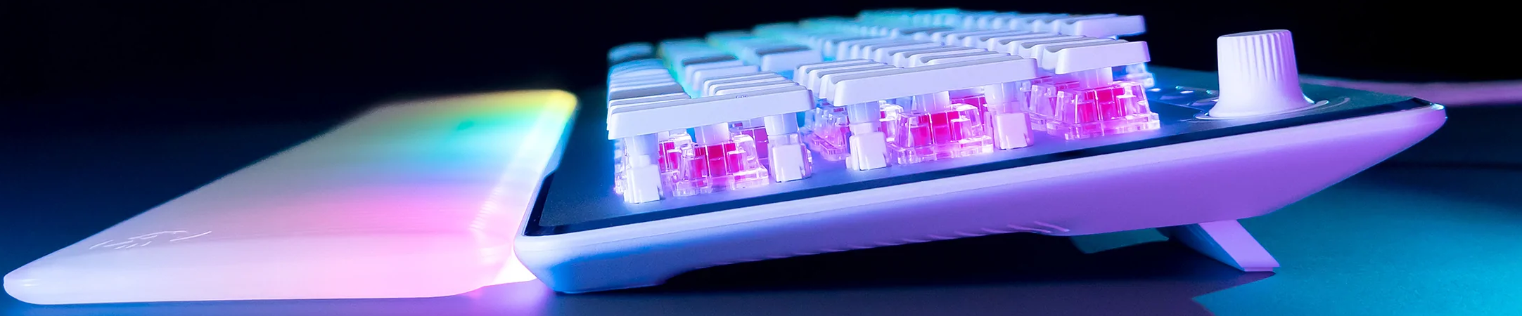 Clavier gaming blanc avec touches blanches, interrupteurs roses et bouton volume blanc.