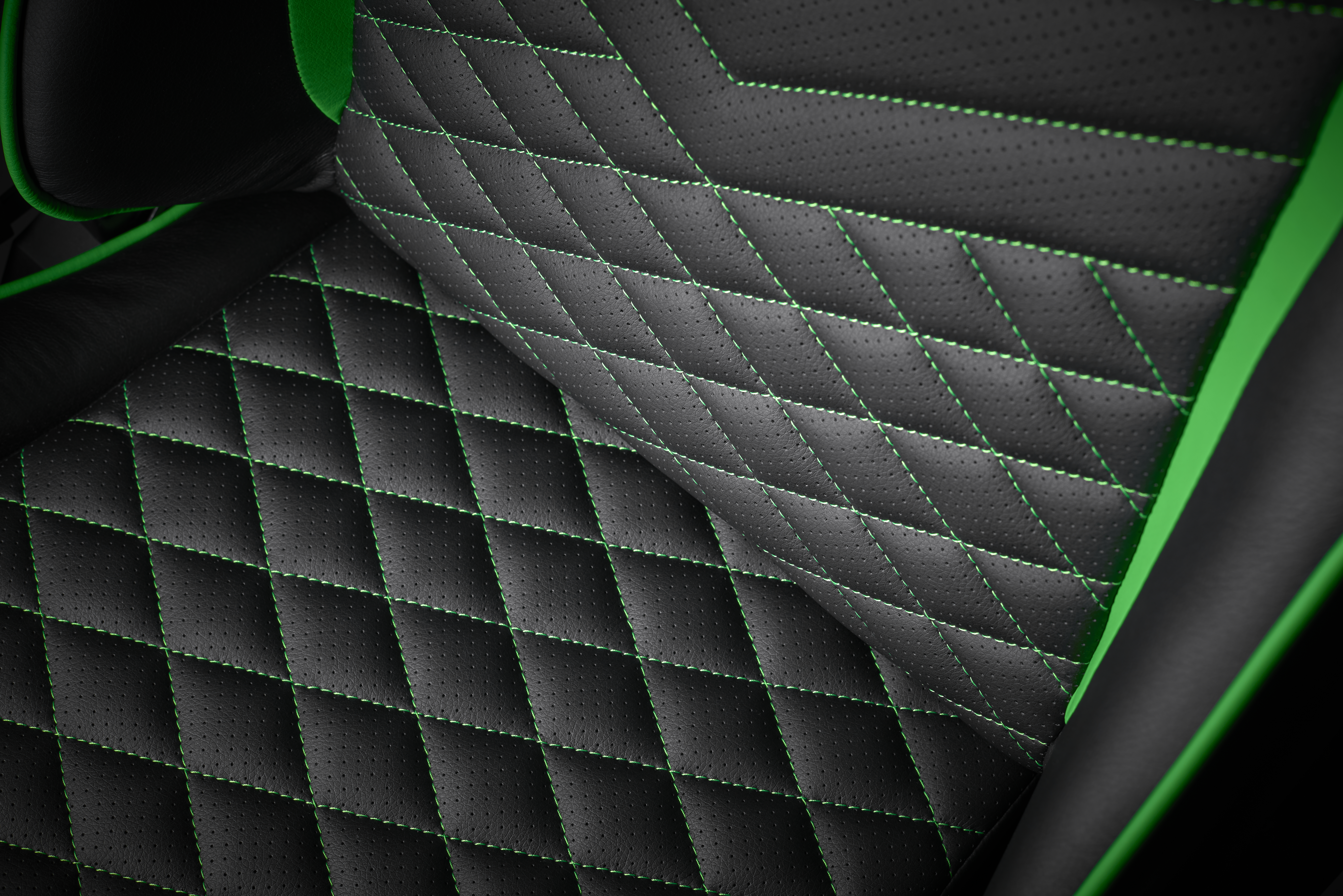 Detailansicht eines schwarz-grünen Gaming-Stuhls. Rautenmuster-Steppung auf Sitz und Rückenlehne.
