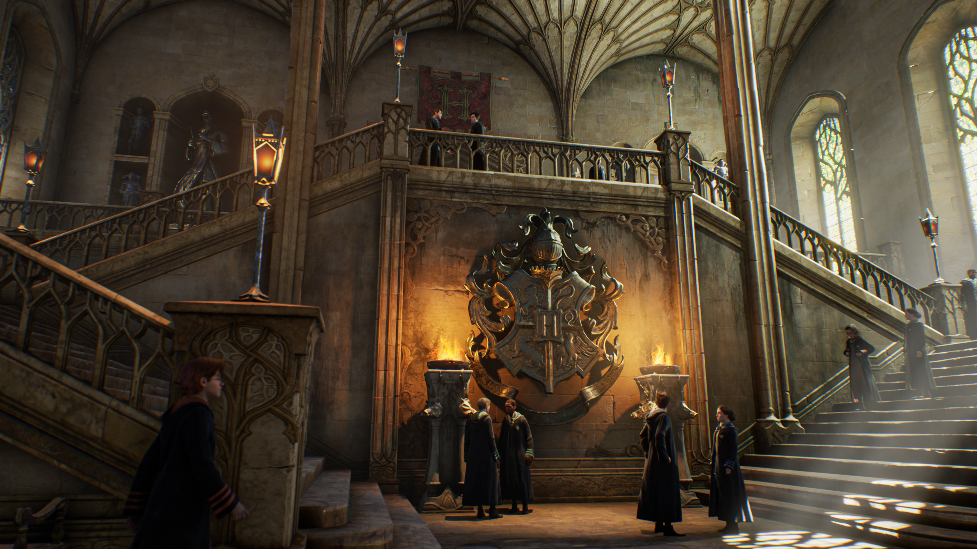 Interior de Hogwarts con estudiantes, escalera y emblema.