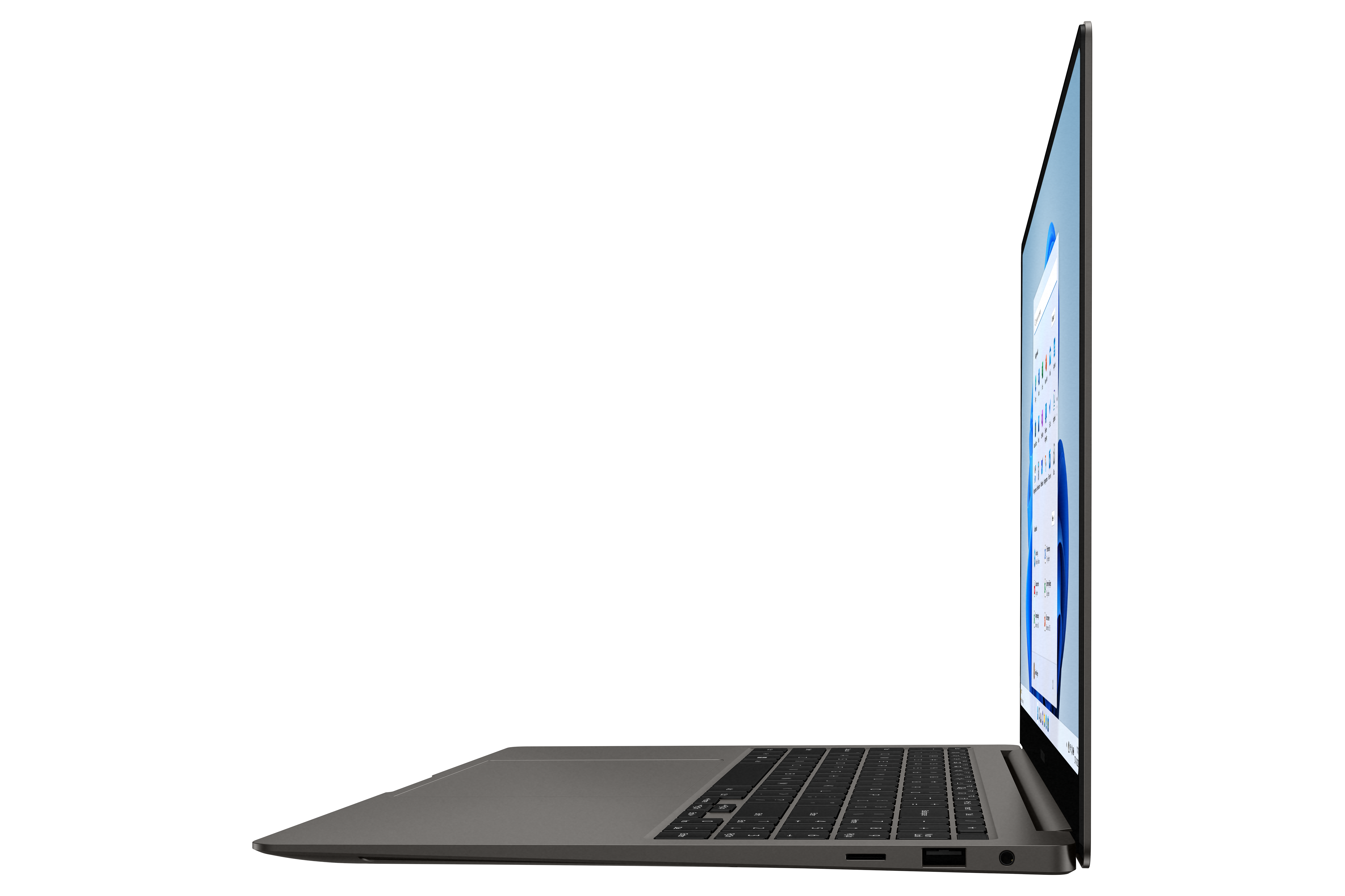 A silver laptop is open, displaying a software interface. The keyboard is visible. The background is black.