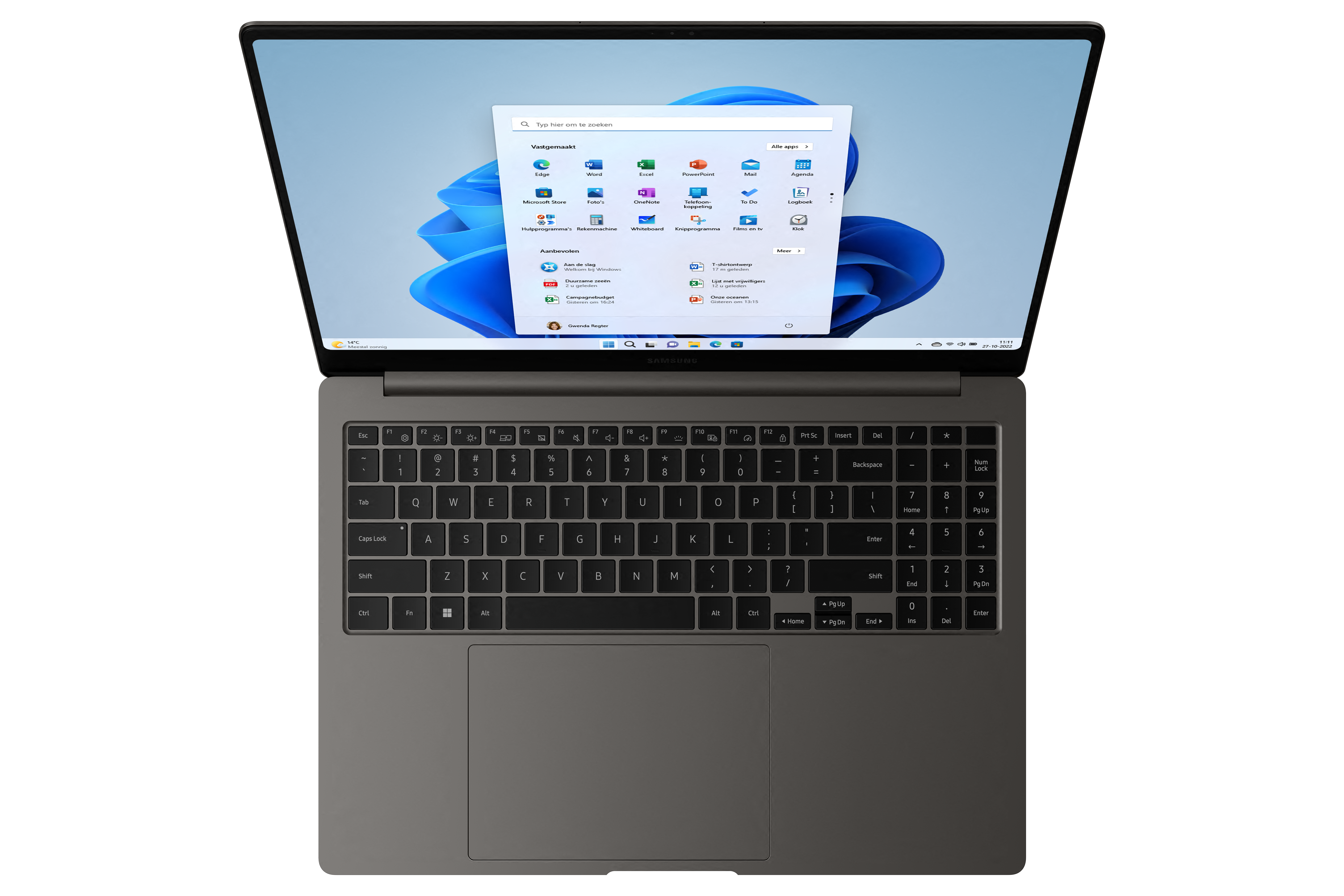 Laptop on a black surface with a Windows interface open, showing app icons. The keyboard is visible.
