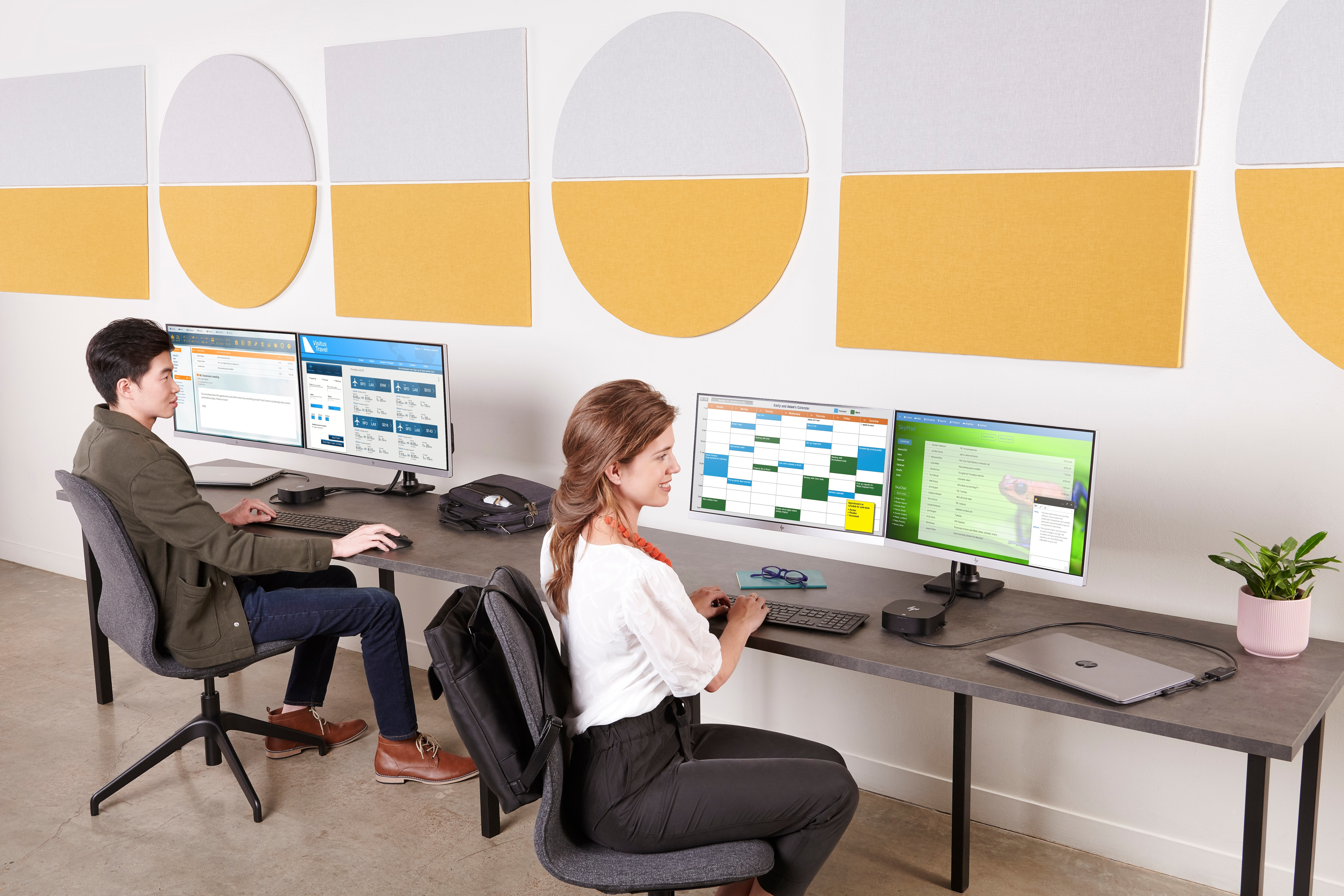 Zwei Personen arbeiten an einem Schreibtisch mit mehreren Monitoren. Hintergrund hat gelbe und weiße Kreise.