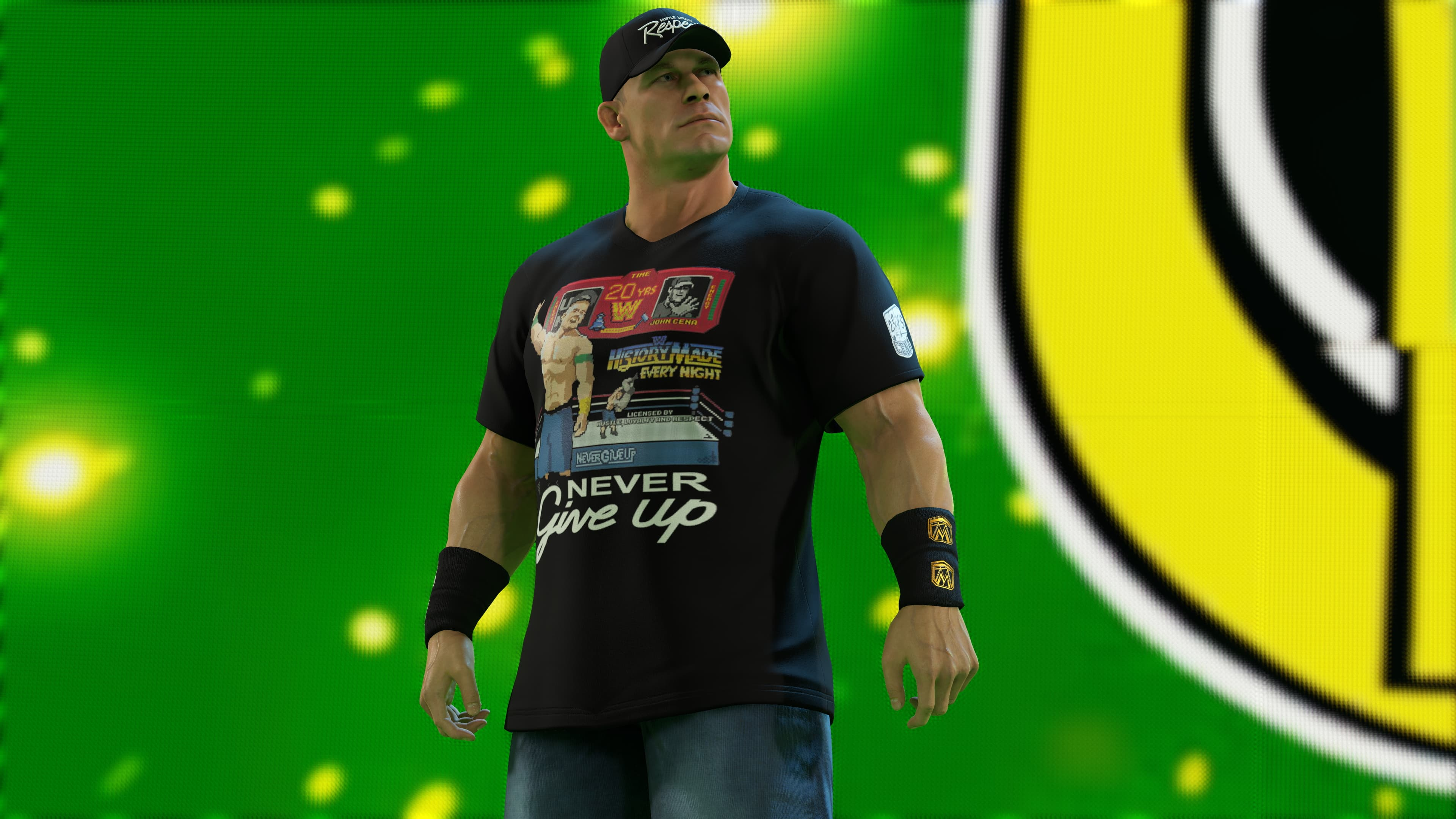 John Cena en tenue de catch. Il porte un t-shirt noir avec une image et une casquette. Il se tient debout, les bras croisés.