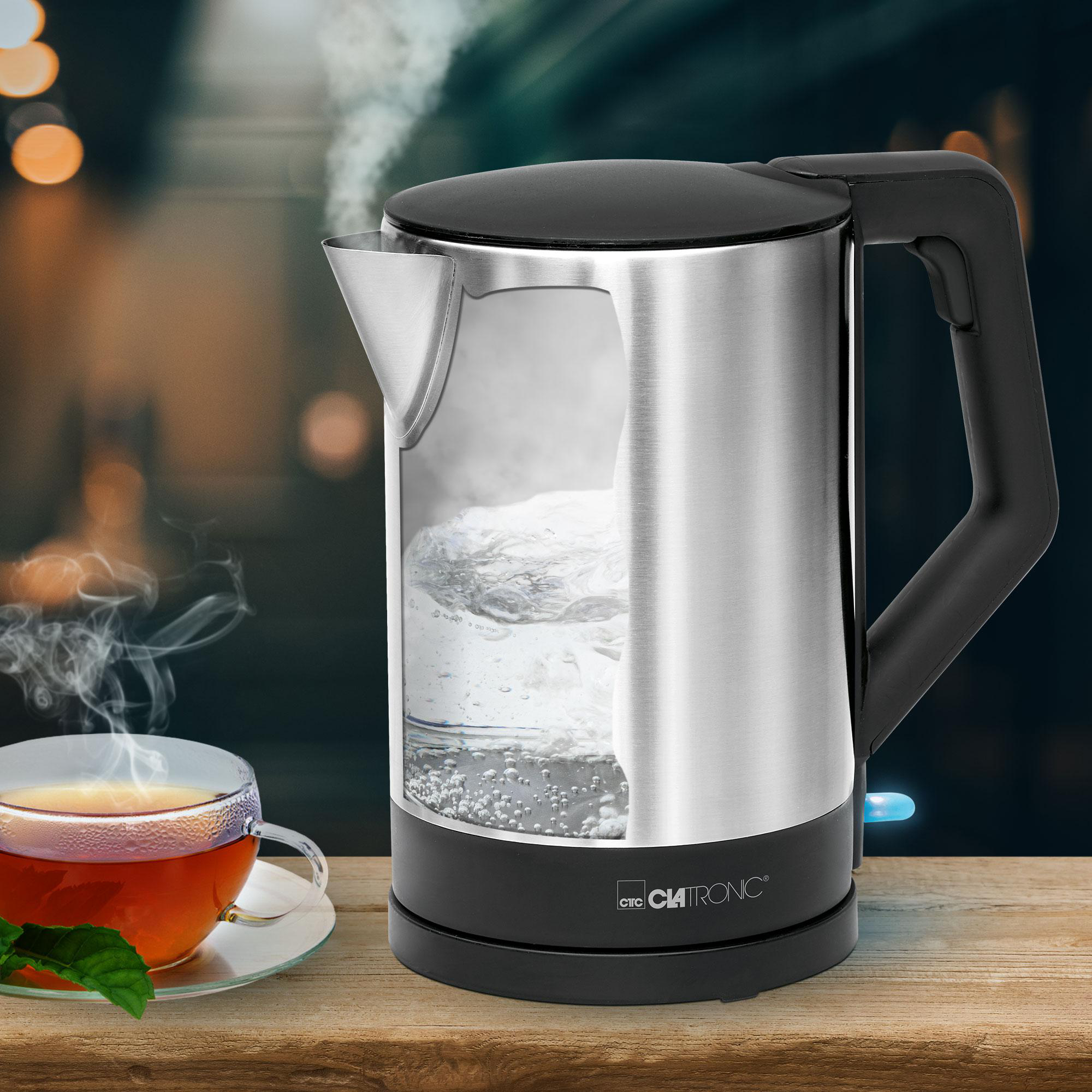 Ein elektrischer Wasserkocher aus Edelstahl mit Wasser im Inneren. Eine Tasse ist vorne.