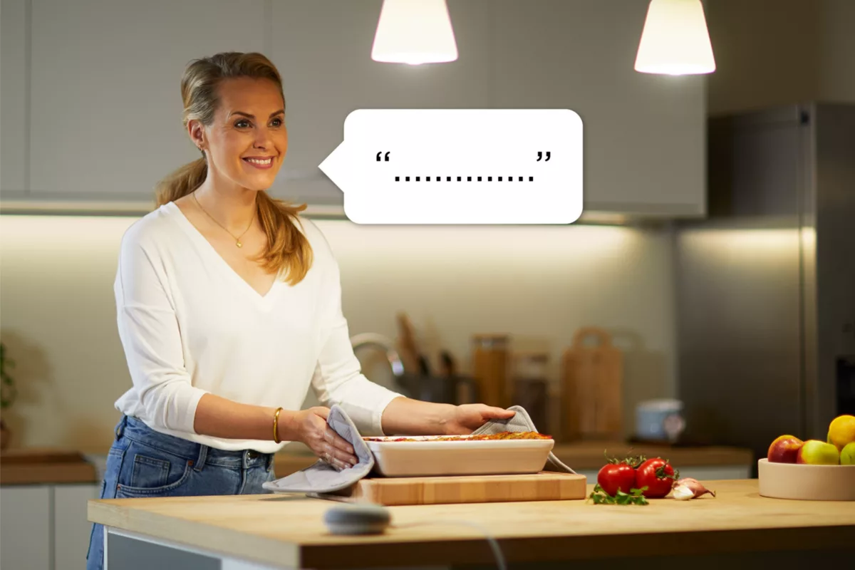 Una mujer en una cocina sosteniendo una fuente para hornear, con una burbuja de diálogo sobre su cabeza.