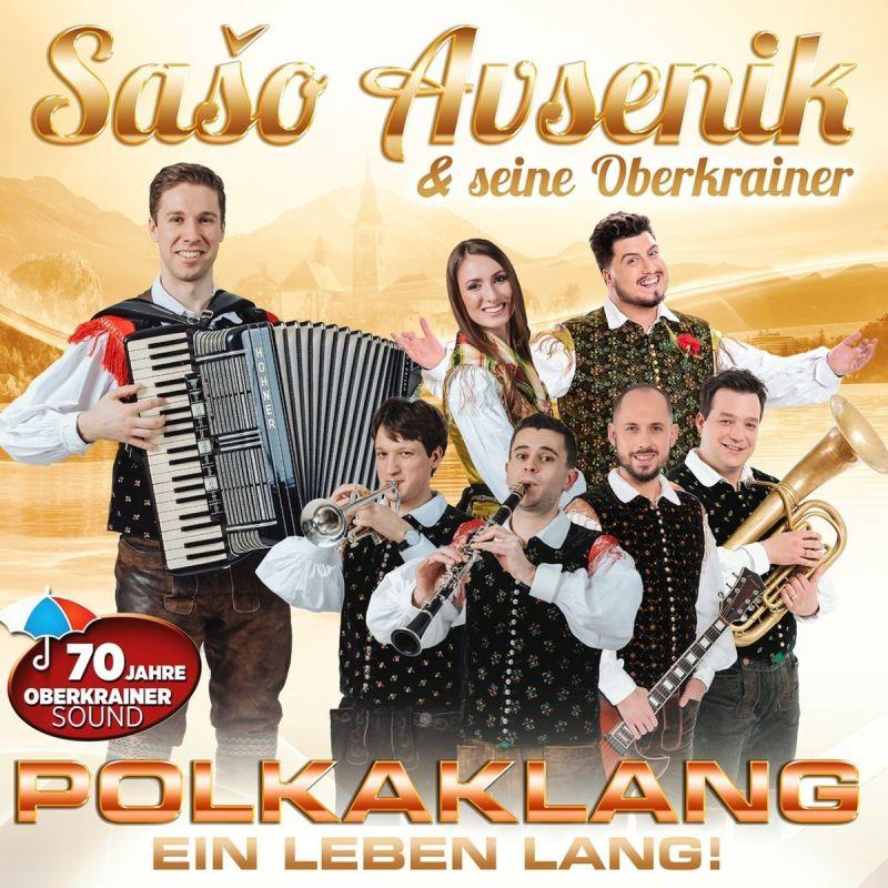 Albumcover mit einer Gruppe von Musikern in Tracht, die Instrumente spielen. Text in Gold.