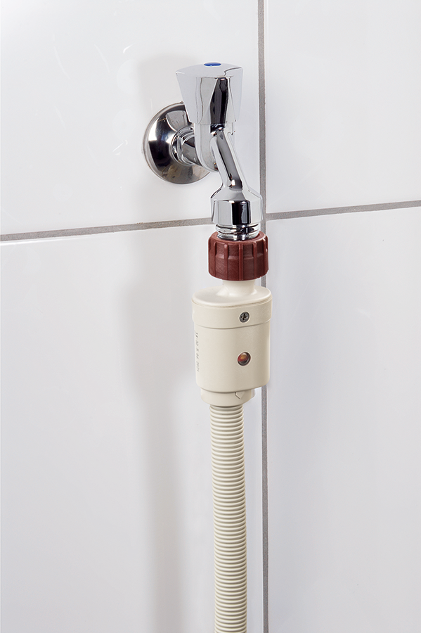 Faucet with water filter attached, white tile background.